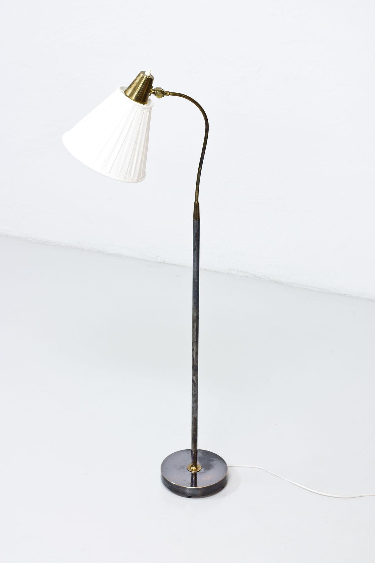 Floor lamp produced in Sweden by Falkenbergs Belysning during the 1950s. Made from oxidized brass and copper. Hand pleated lamp shade in off-white chintz fabric. New wiring.