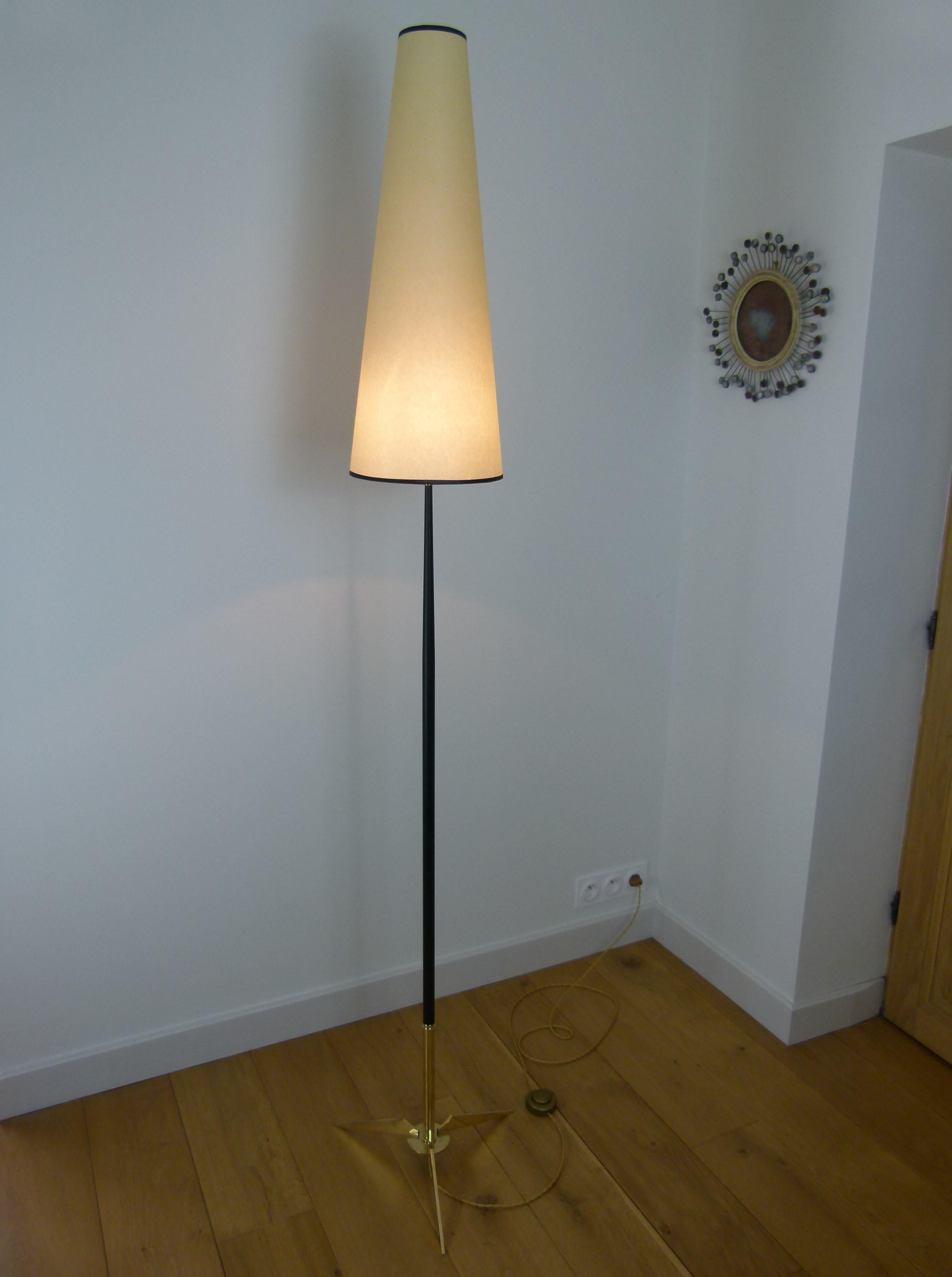 Floor lamp in black lacquered metal and solid brass, consisting of a tripod foot solid brass, topped with a conical black lacquered metal, ending with a brass ring, on which is placed a conical shade, diffusing the light.
This floor lamp has been
