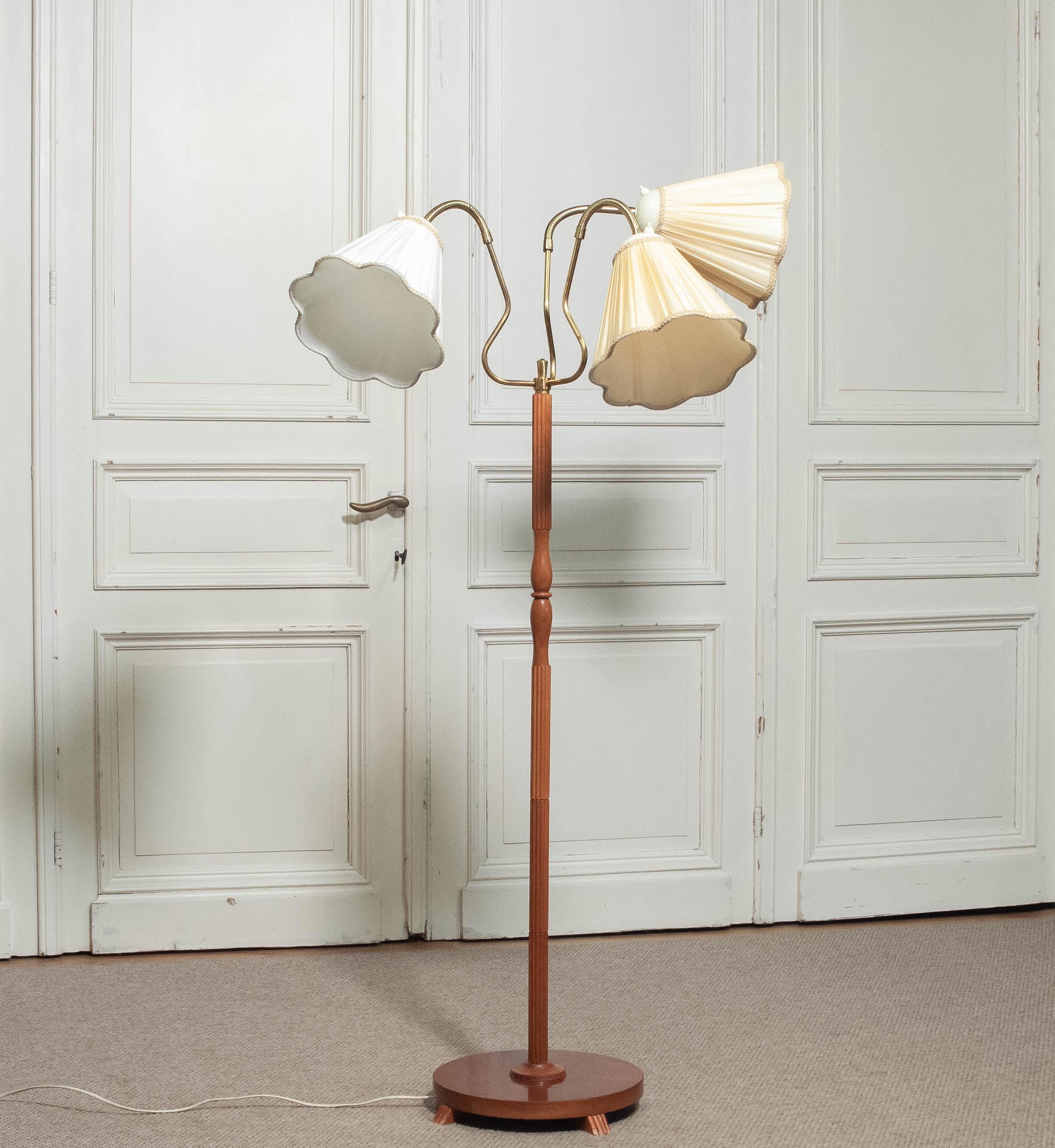 Lámpara de pie de los años 50 fabricada por Orsjö, Suecia, modelo 236. Esta elegante pieza escandinava tiene un soporte de madera de haya torneada sobre una base redonda chapada en teca con cuatro pequeños pies. La lámpara tiene tres pantallas de