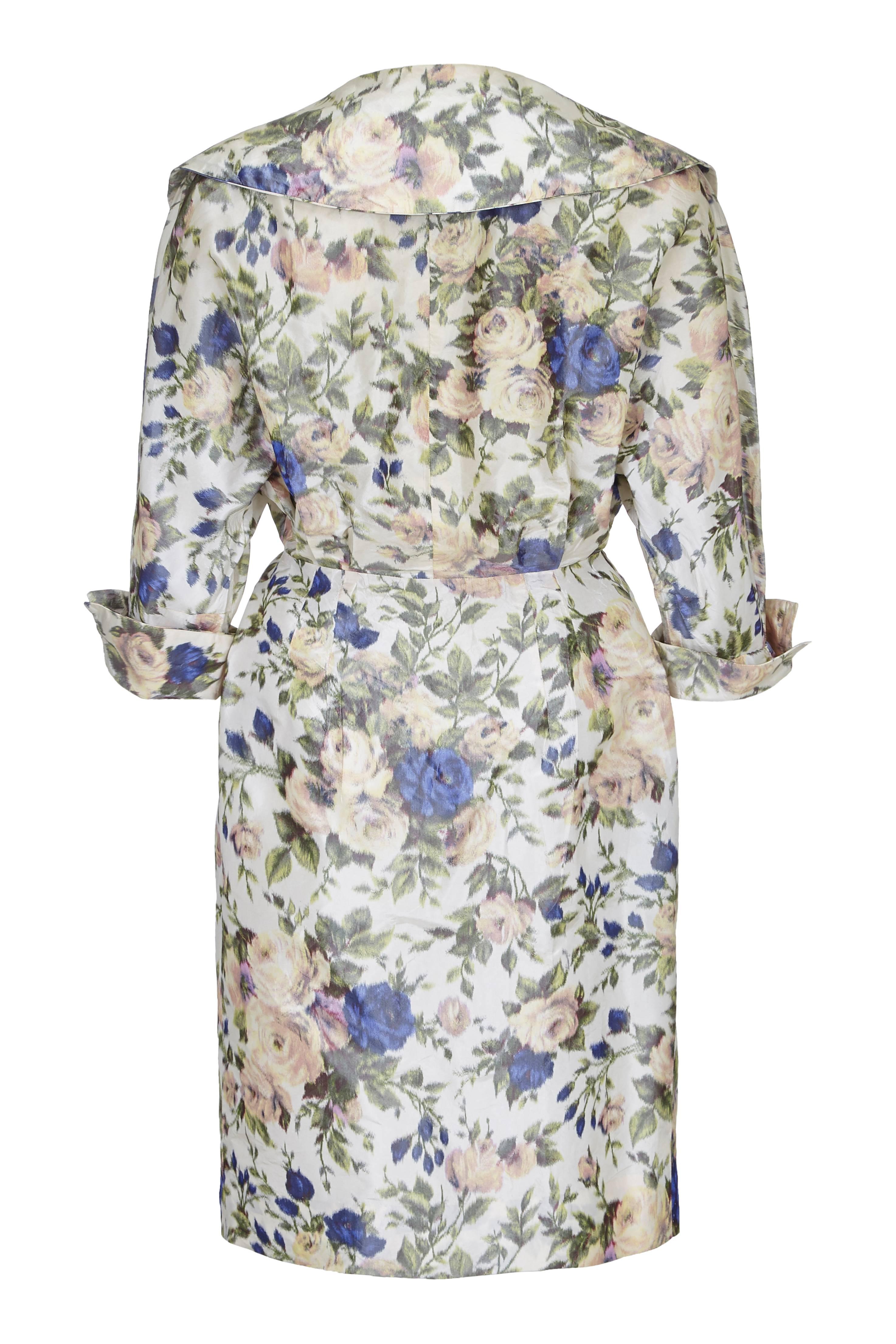 This stylish 1950s French couture silk taffeta rose print dress has a classic 50s ‘New Look’ style features a nipped in waist, broad lapelled collar and oversized fabric-covered buttons. The rose print in gentle pastel tones and contrasting with