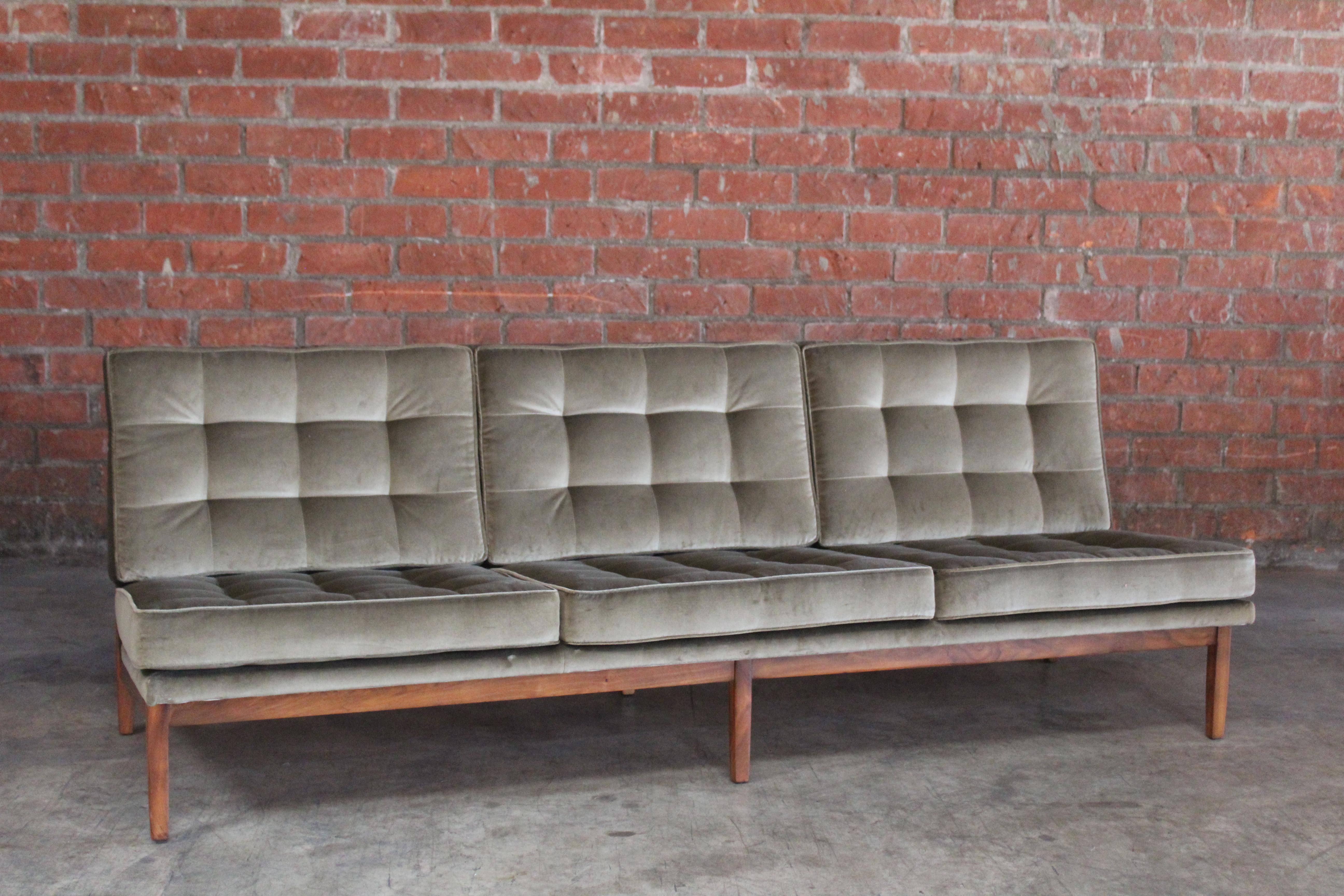 A vintage 1950s sofa designed by Florence Knoll. Completely restored and reupholstered in new Italian cotton velvet in olive green. The walnut frame has been refinished.