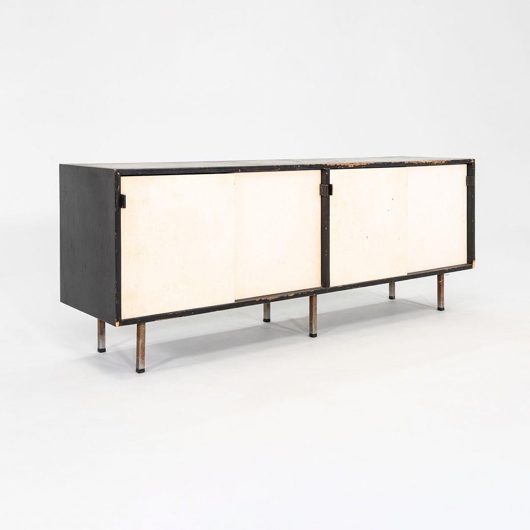 This is a 1950s Sliding Door Credenza in Black and White, Model 541, designed by Florence Knoll for Knoll Inc. circa 1949. The piece features an ebonized walnut case and has white lacquered doors. The sliding doors open to reveal adjustable shelves