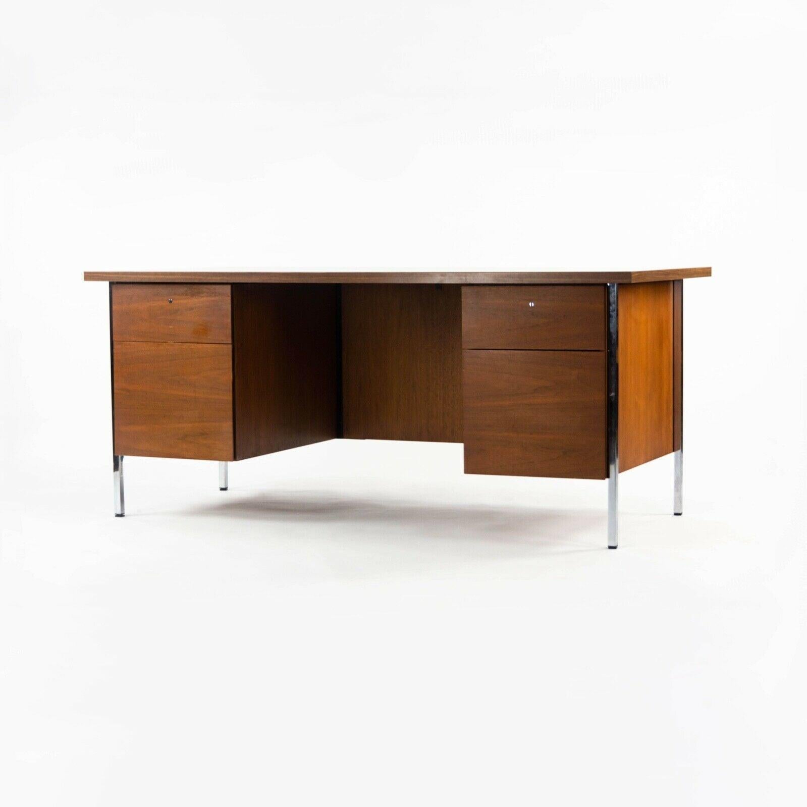 Listed for sale is a double pedestal desk, model 1503, designed by Florence Knoll and produced by Knoll Associates. This is an original example dating to circa late 1950s. It is constructed from walnut for the doors, sides, and back. The legs are