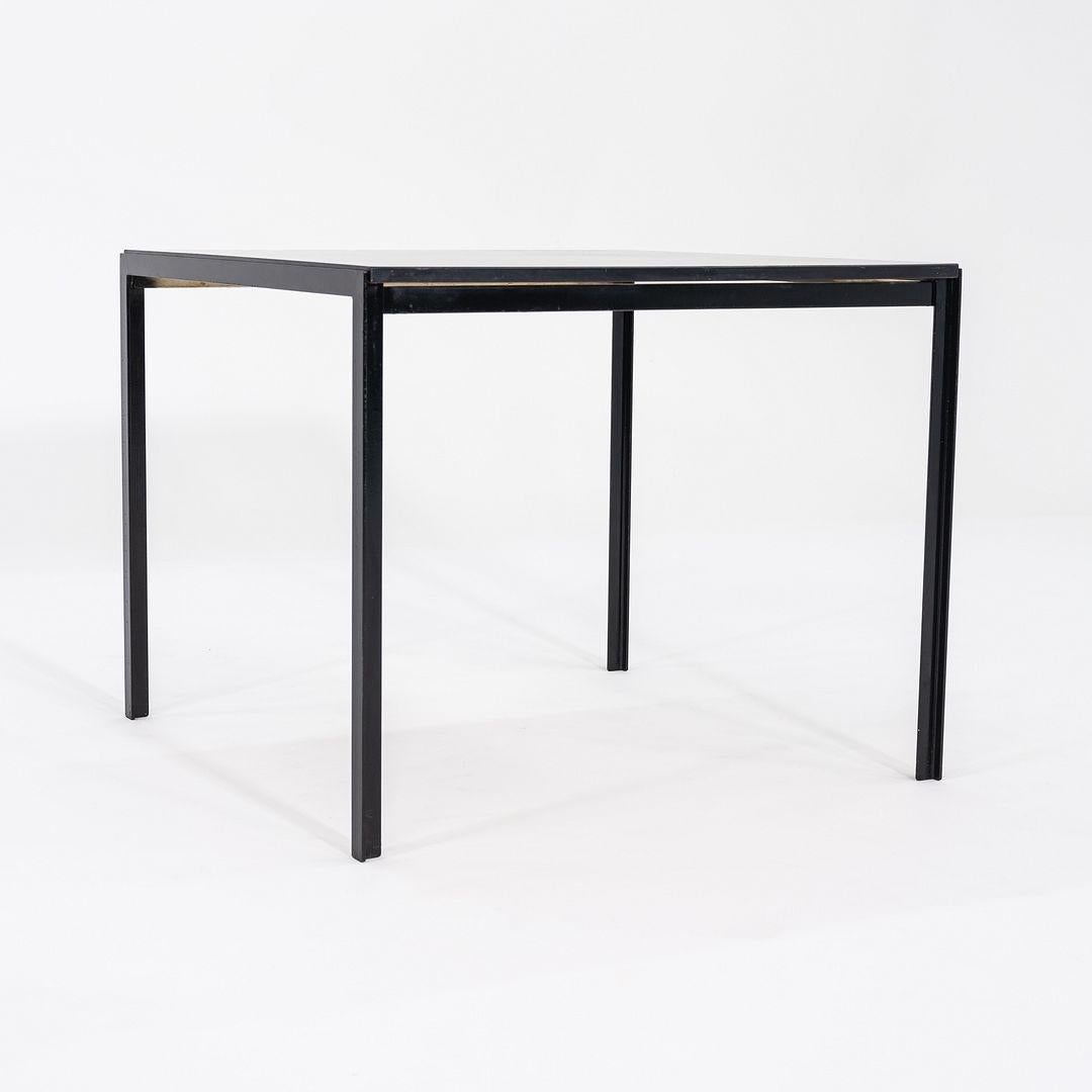 Il s'agit d'une table de salle à manger AT&T, modèle 309, conçue par Florence Knoll pour Knoll International en 1952. Cet exemple particulier date des années 1950. Il présente un plateau carré en stratifié/formica noir et des pieds en acier émaillé