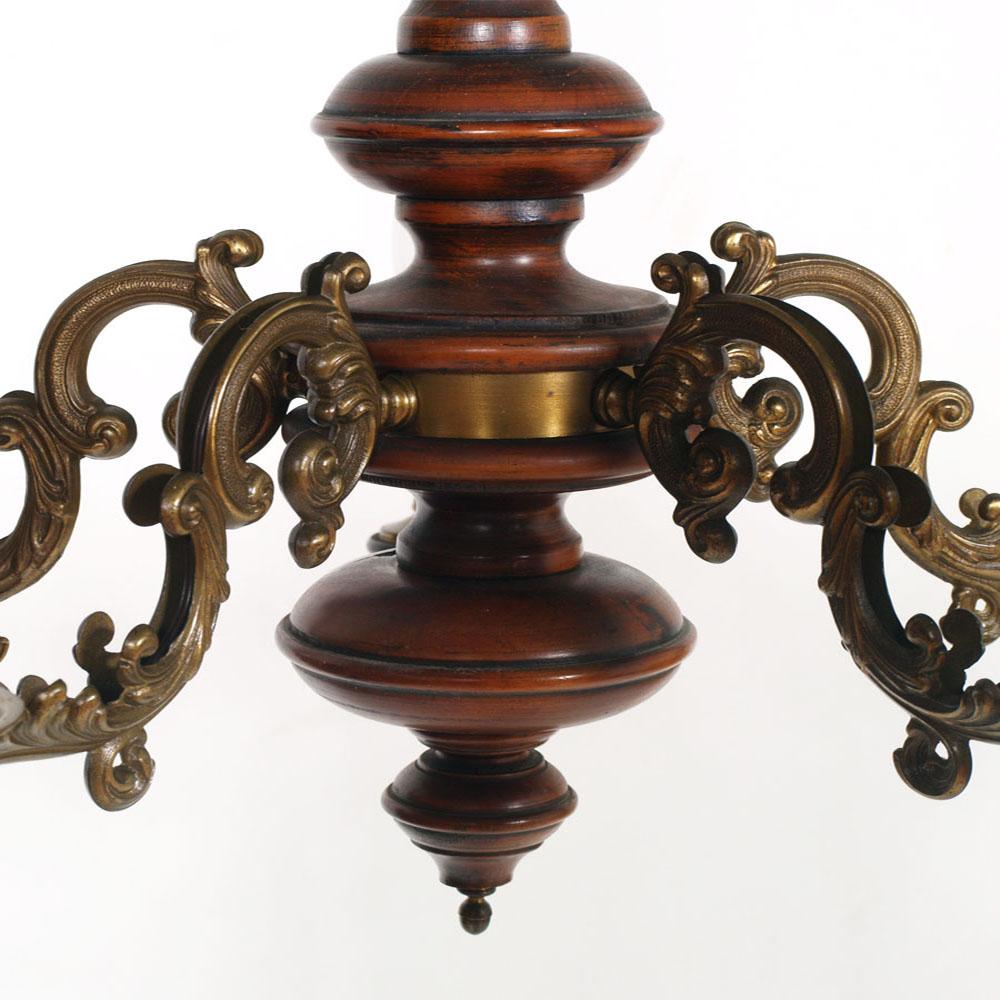 Italian ceiling chandelier in turned wood of walnut with arms of bronze, Baroque style, with six arms, decorated wood red antique, restored and ready to use.