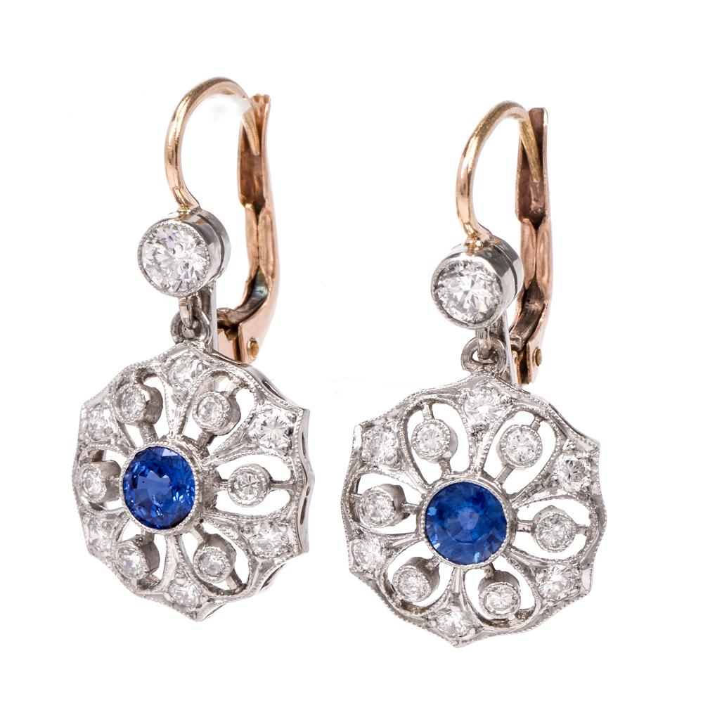 These vintage flower diamond and sapphire earrings are crafted in solid platinum and 18K gold. Displaying a feminine flower design with a center round cut sapphire approx. 0.80cts. The petals are depicted by round cut diamonds approx. 0.85cts.