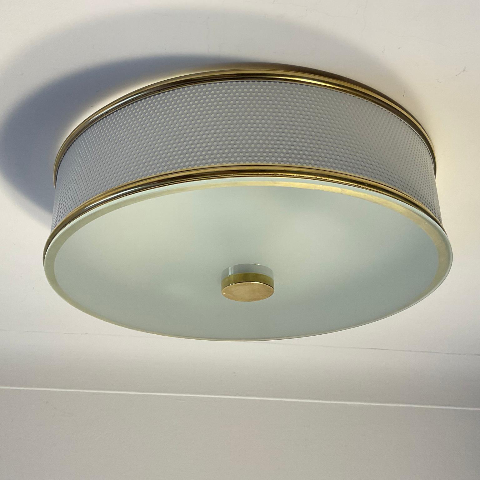 Large unusual flush mount from the 1950s attributed to Pierre Guariche and produced by Maison Arlus. The shade frame is white perforated metal surrounded by a copper ring with a frosted glass top finish.
Fully rewired with 4 lamp sockets.
