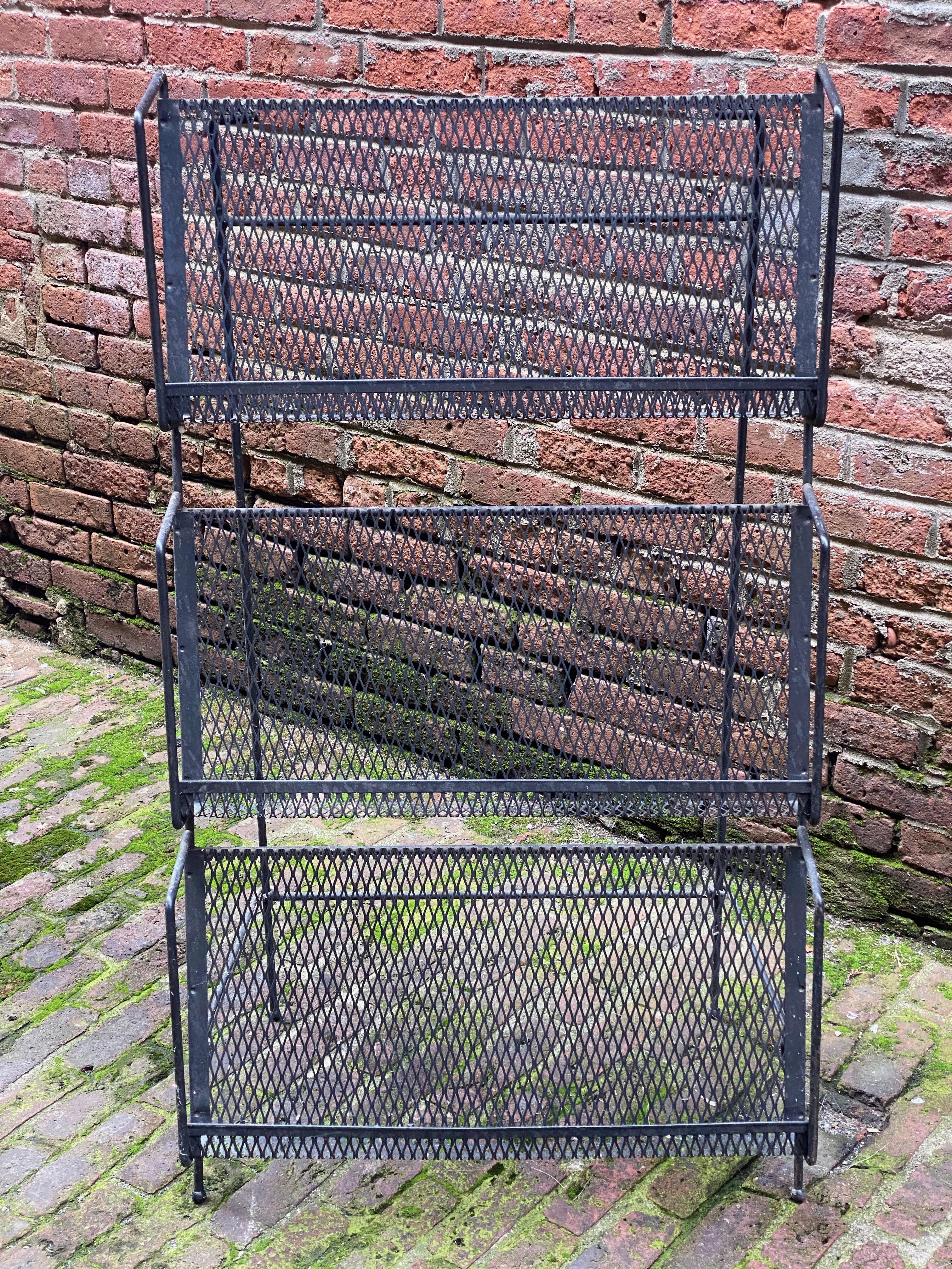 A great display item for your books, magazines or any media. Three iron and mesh shelves that can fold up flat for transport, circa 1950-1960. Shelf depth is 2.5