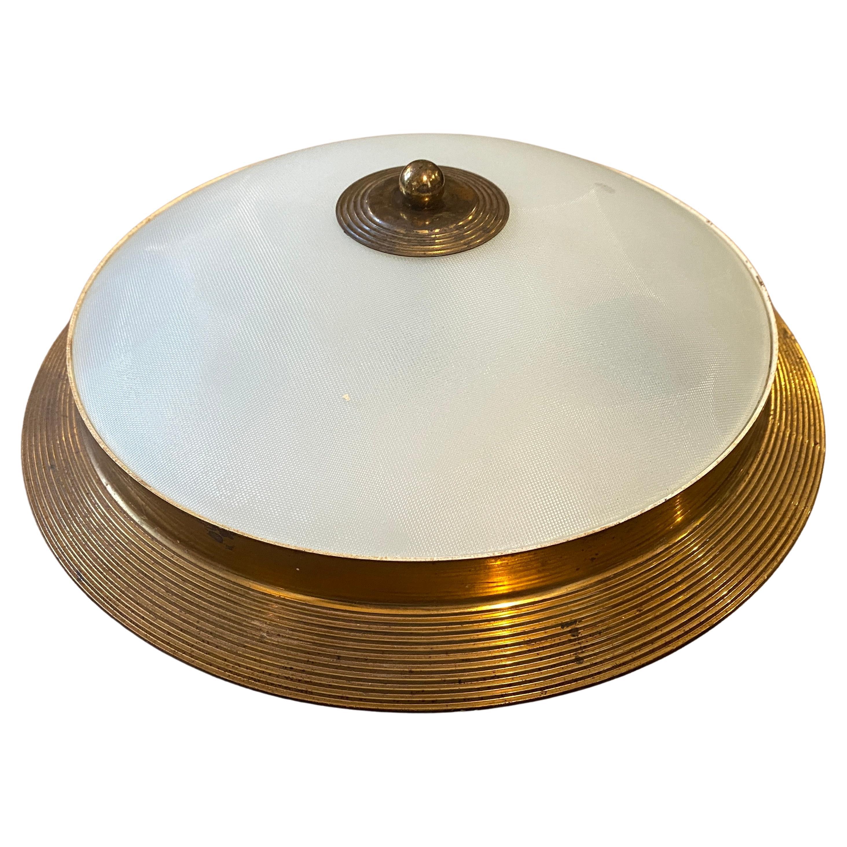 High quality, style and type of glass of this ceiling light gives to it a Fontana Arte attribution. Brass it's in original patina, the knurled glass it's in perfect conditions. It works 110-240 Volts and needs regular e14 bulbs.