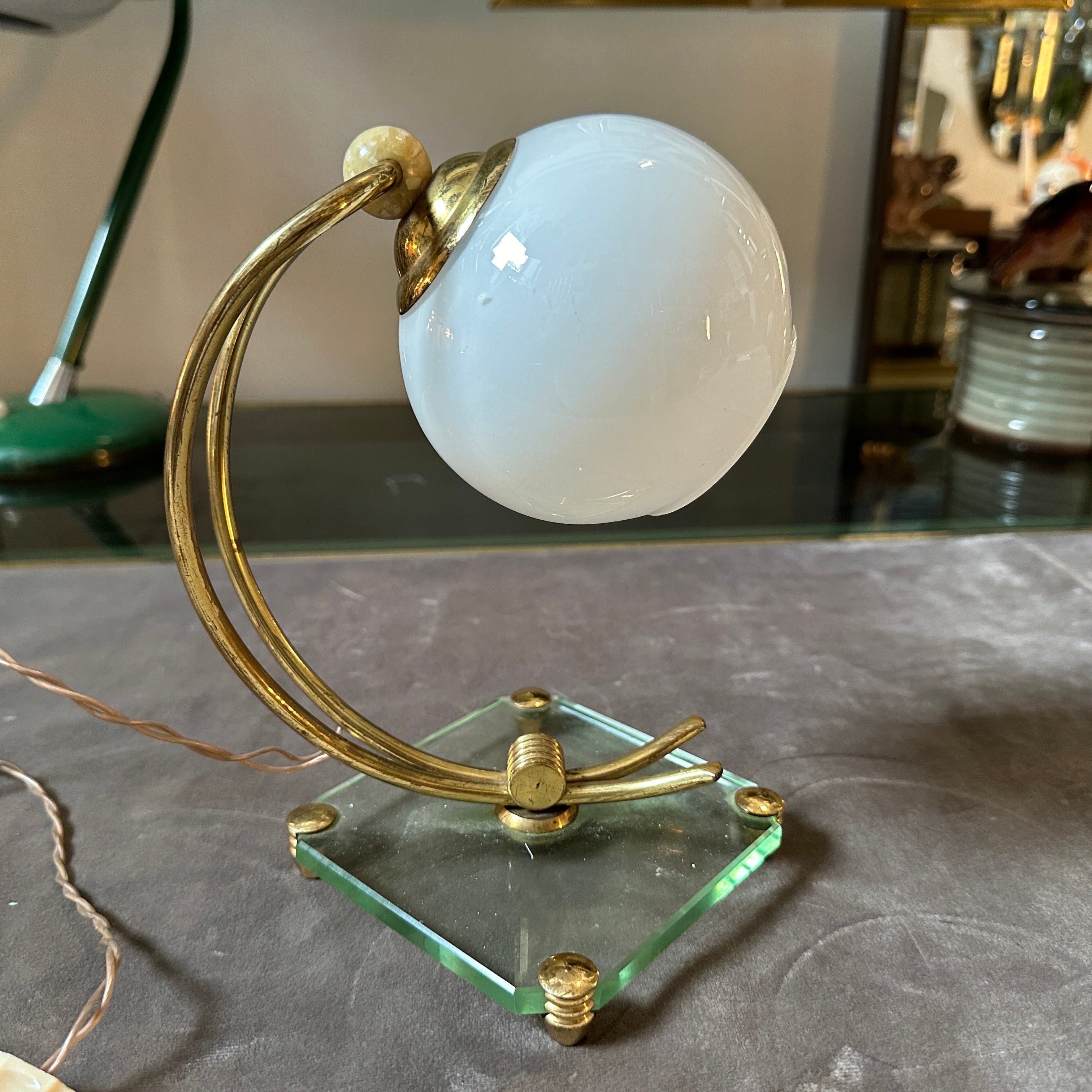 A lovely mid-century modern table lamp designed and manufactured in Italy in the Fifties in the manner of Fontana Arte. High quality Verde Nilo Glass and Brass are in perfect vintage condition, it's in working order with original electrical