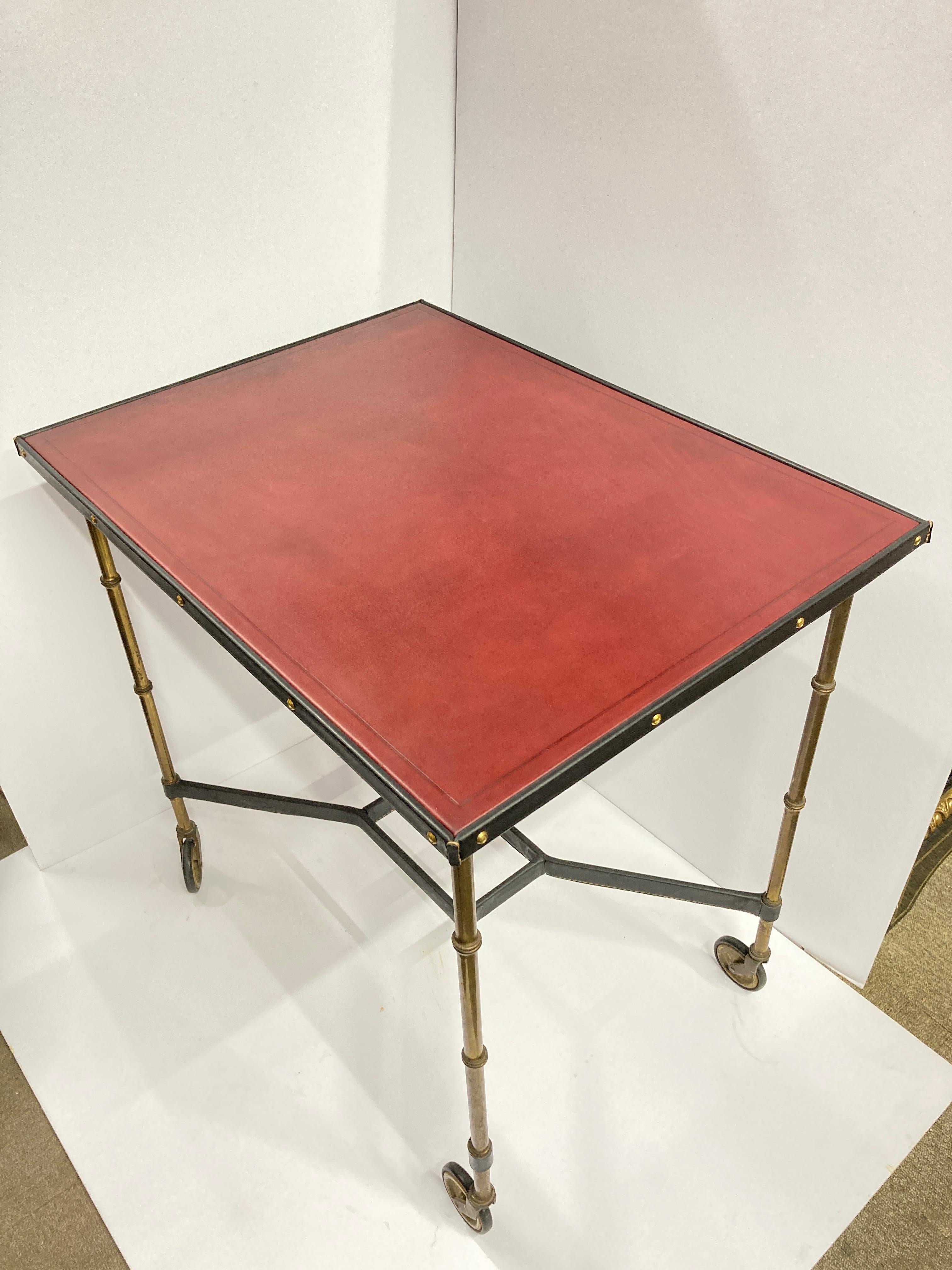 Großer Tisch auf Rad 
Genähtes Leder, schwarz und burgunderrot 
Messingfüße wie Bambus
Möglichkeit, ein Glas auf dem unteren Teil hinzuzufügen 
