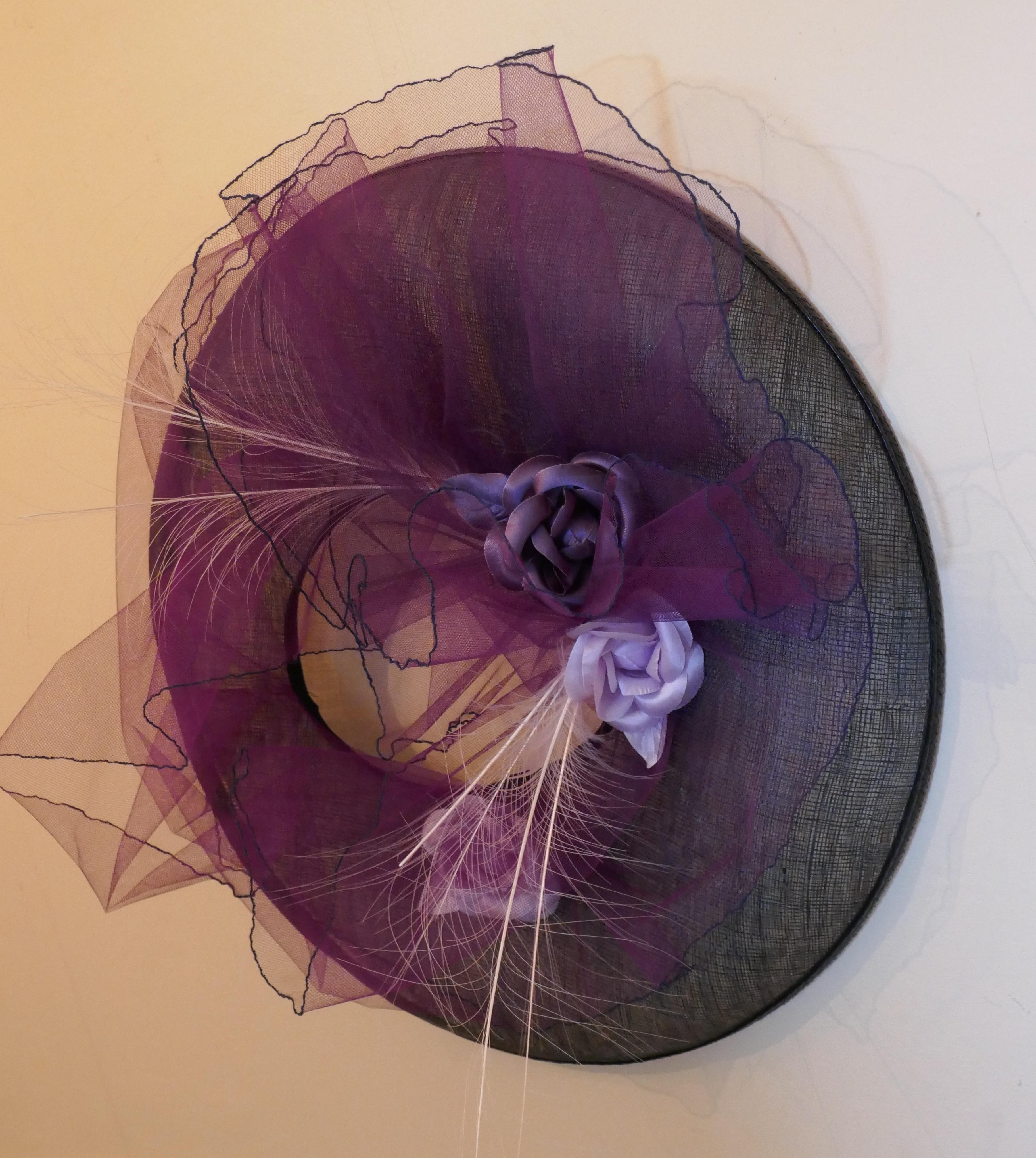 1950s Formal Summer Garden Party Hat, la Tribe des Oiseaux

Stunning Design from a Channel Islands Designer, the hat has large black mesh brim, with an open crown, it is decorated with silk flowers and ostrich feather quills, all brought together