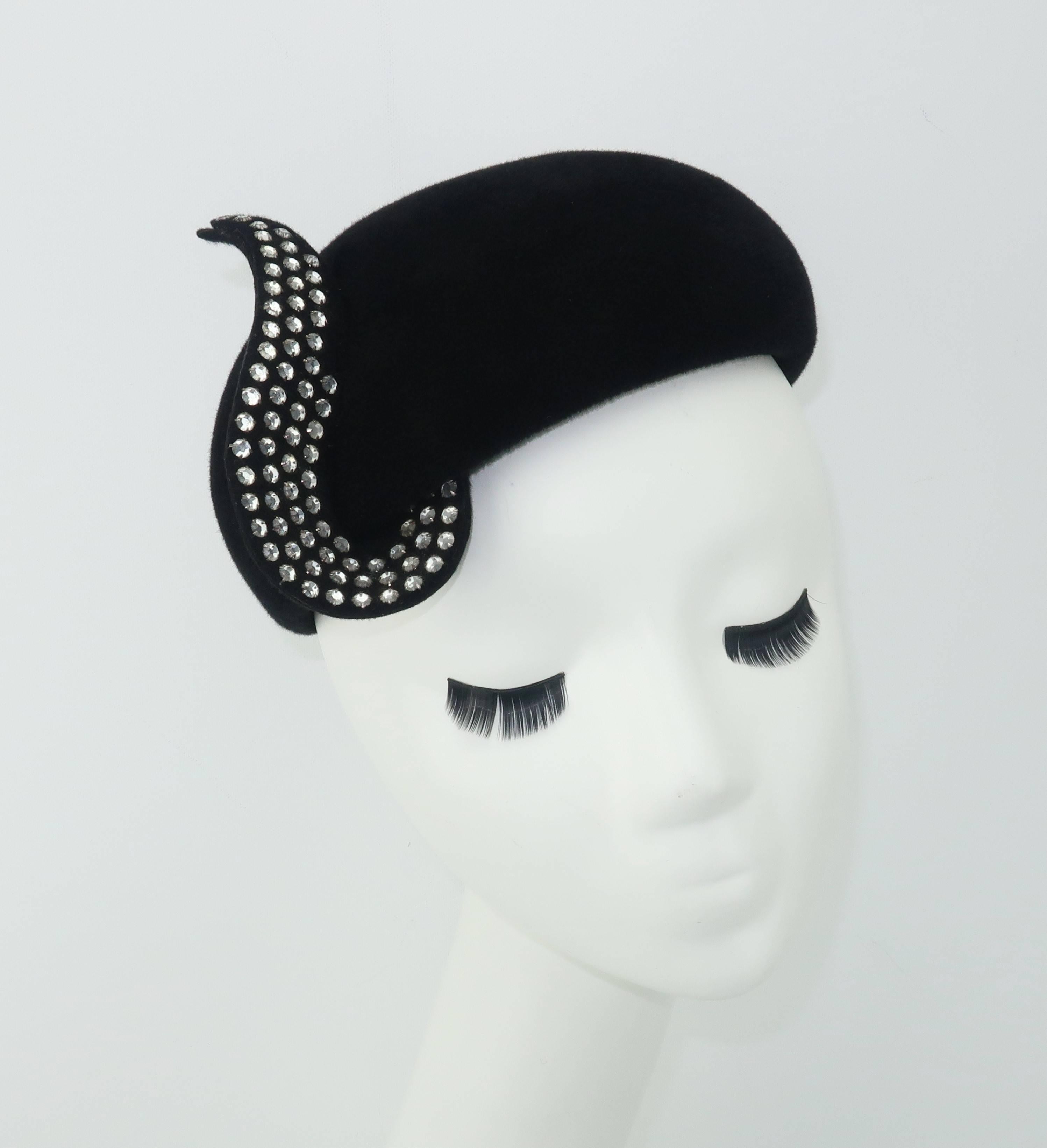 A touch of class!  This vintage Frank Olive black wool hat has a glamorous personality with a close fitting skull cap silhouette embellished by a whimsical pave crystal curlicue that catches the light with every turn.  The design recalls Mr. Olive's