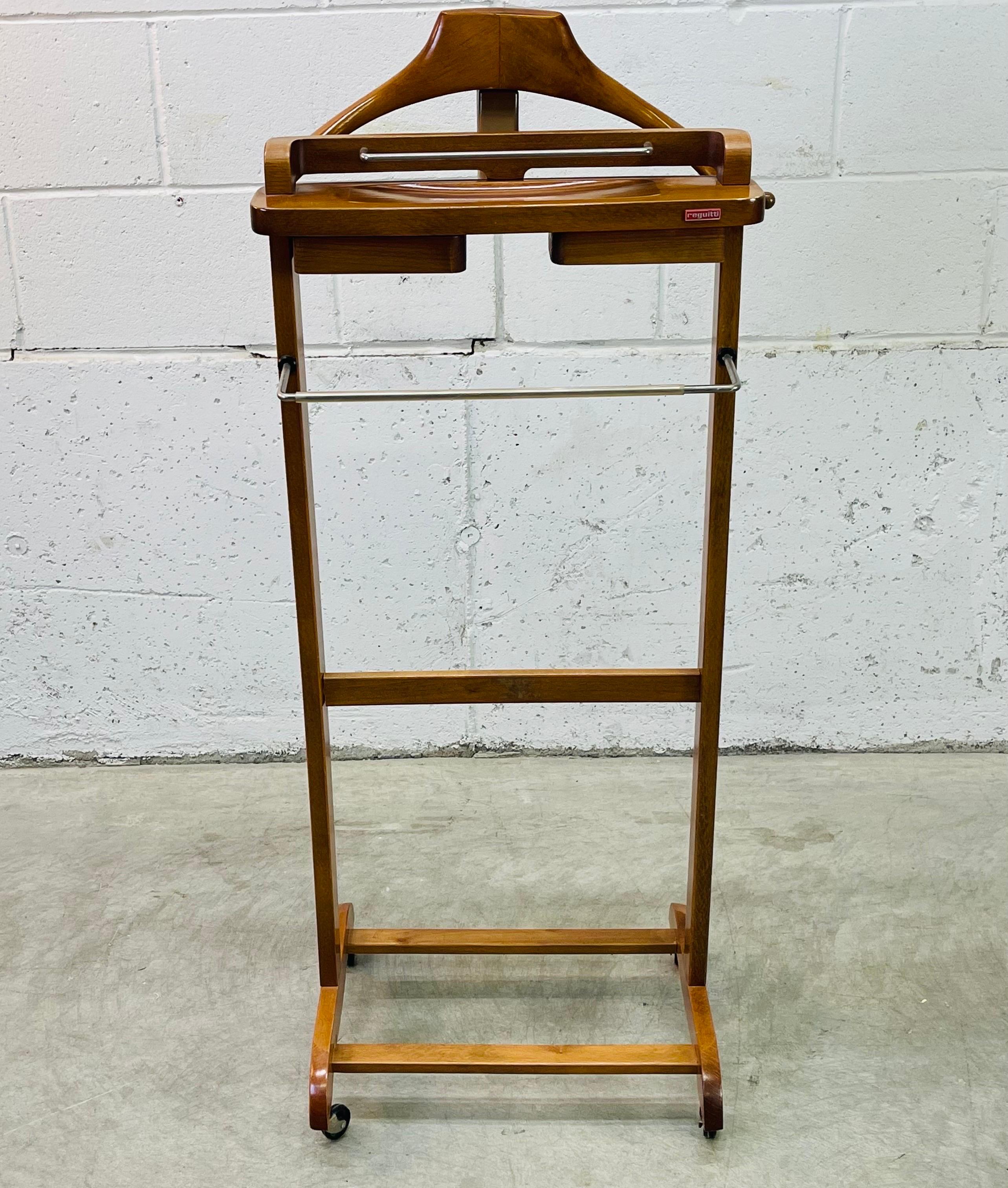 Vintage 1950s Fratelli Reguitti maple wood rolling Italian men’s valet stand. This stand has two moving change compartments and a metal rack for pants storage. It also has an additional shelf for storage. Marked on the front.