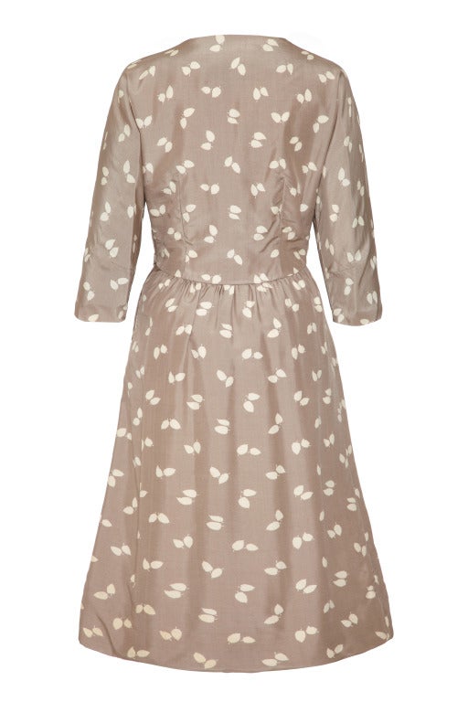 This elegant 1950’s silk printed dress in soft grey is by sought after designer Frederick Starke, a favourite amongst celebrities of this era and in beautiful vintage condition. The dress has a very pretty white leaf print on a pale grey silk