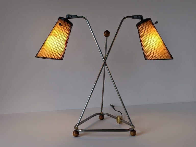 Rare table lamp designed and fabricated by Frederick Weinberg with characteristic steel mesh and fiberglass shade.

Raw metal structure assembled with brass welding.

Well aged wood eyeball feet and accent.

 Solid well made