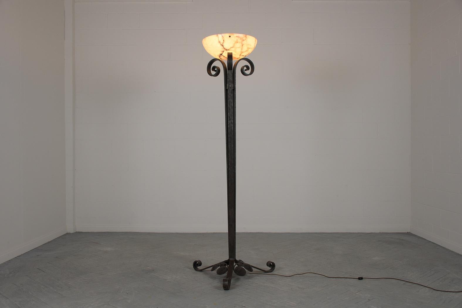 Presenting our meticulously restored 1950s French Art Deco Floor Lamp, masterfully crafted from wrought iron. This exceptional lamp, in top-notch condition, showcases intricate scroll designs at its apex and base, harmoniously complemented by