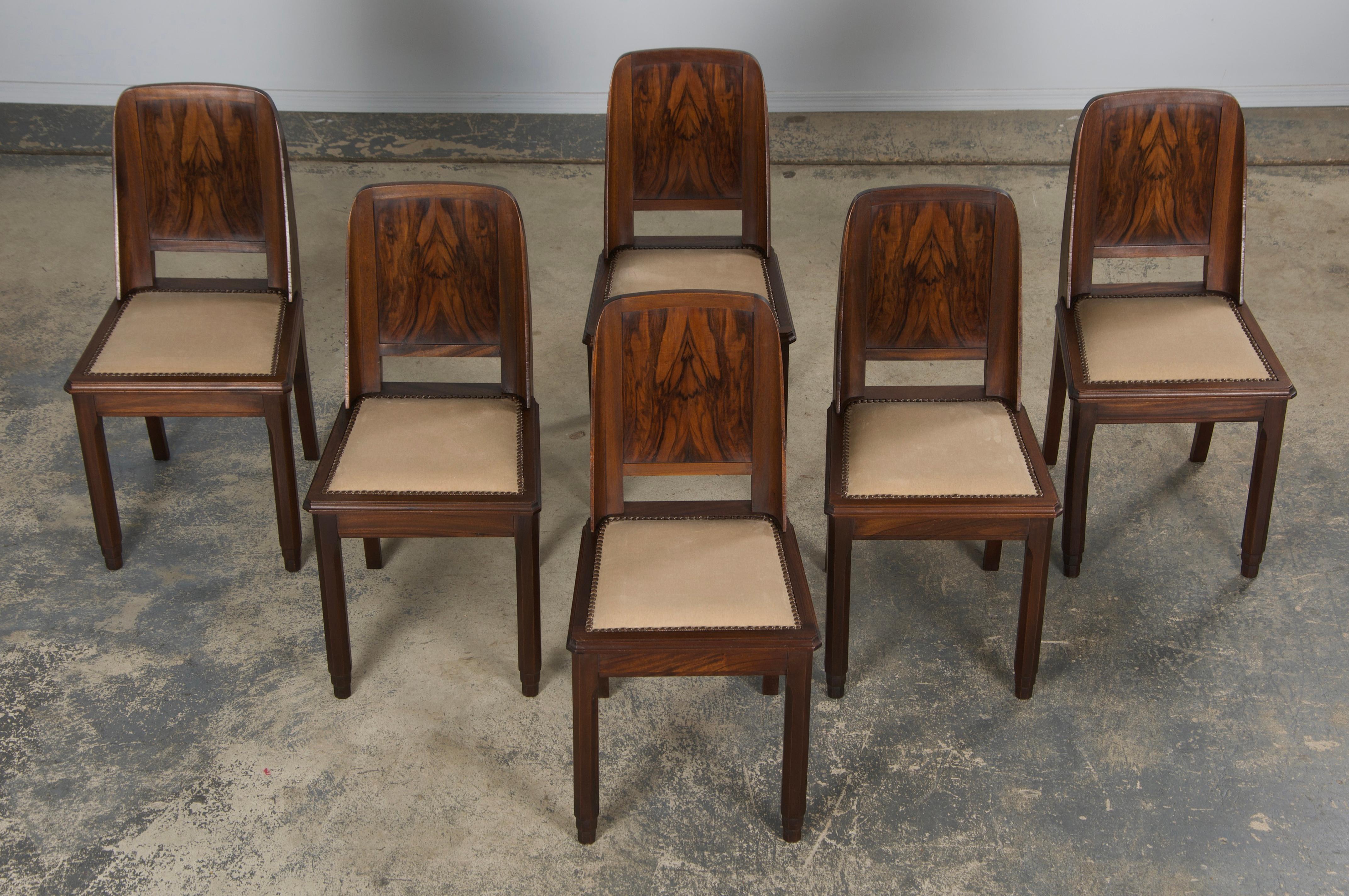 Un elegante set di sei sedie da pranzo francesi Art Déco degli anni '50, provenienti dalla Provenza. Sapientemente realizzata a mano in mogano massiccio, ogni sedia presenta uno schienale quadrato con angoli arrotondati e un profilo laterale