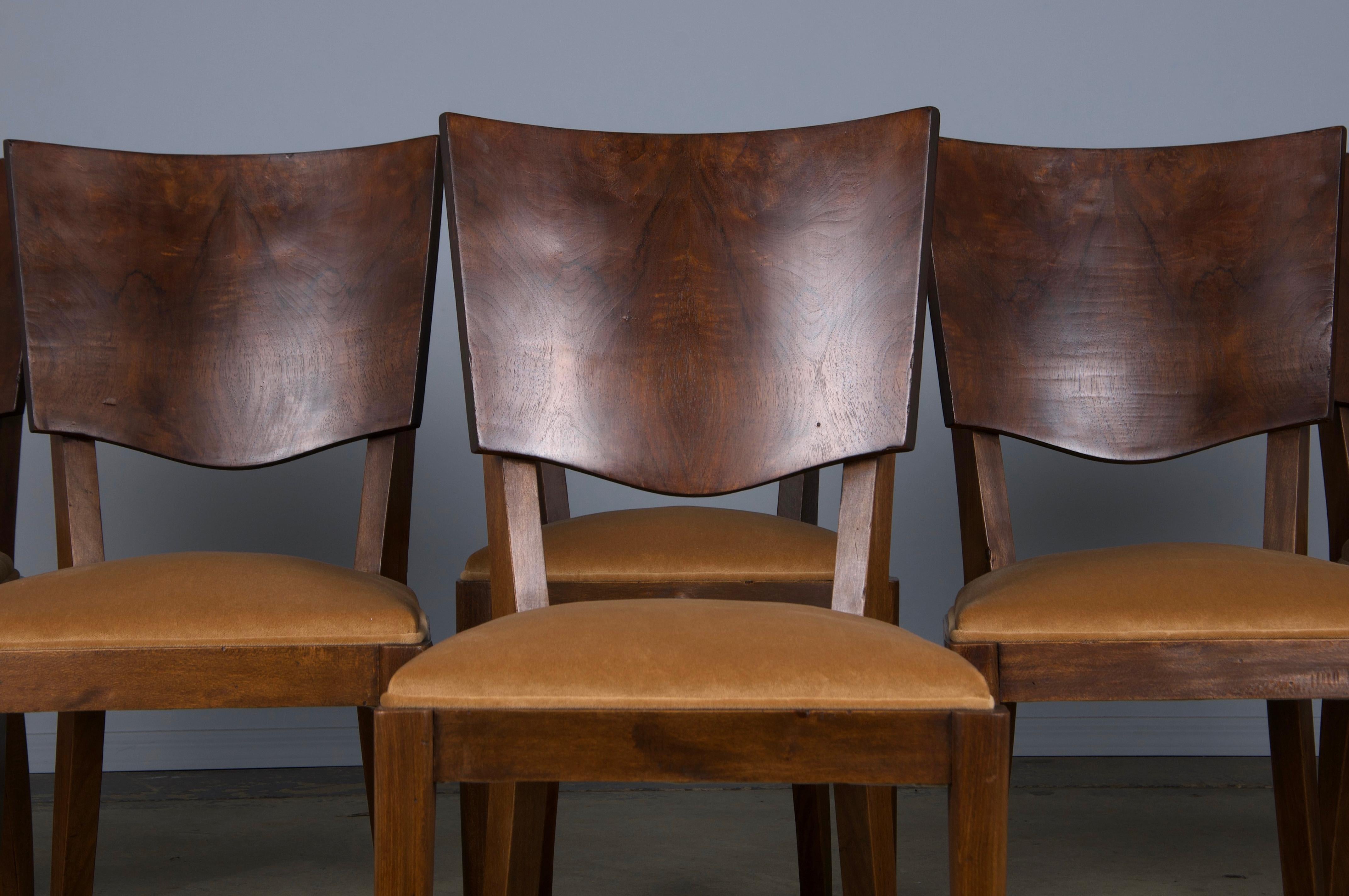 A delightful set of six 1950s French Art Deco dining chairs, sourced directly from Provence, France. Expertly hand-crafted from solid maple wood, these chairs feature a petite profile and elegantly curved backs adorned with stunning burl walnut
