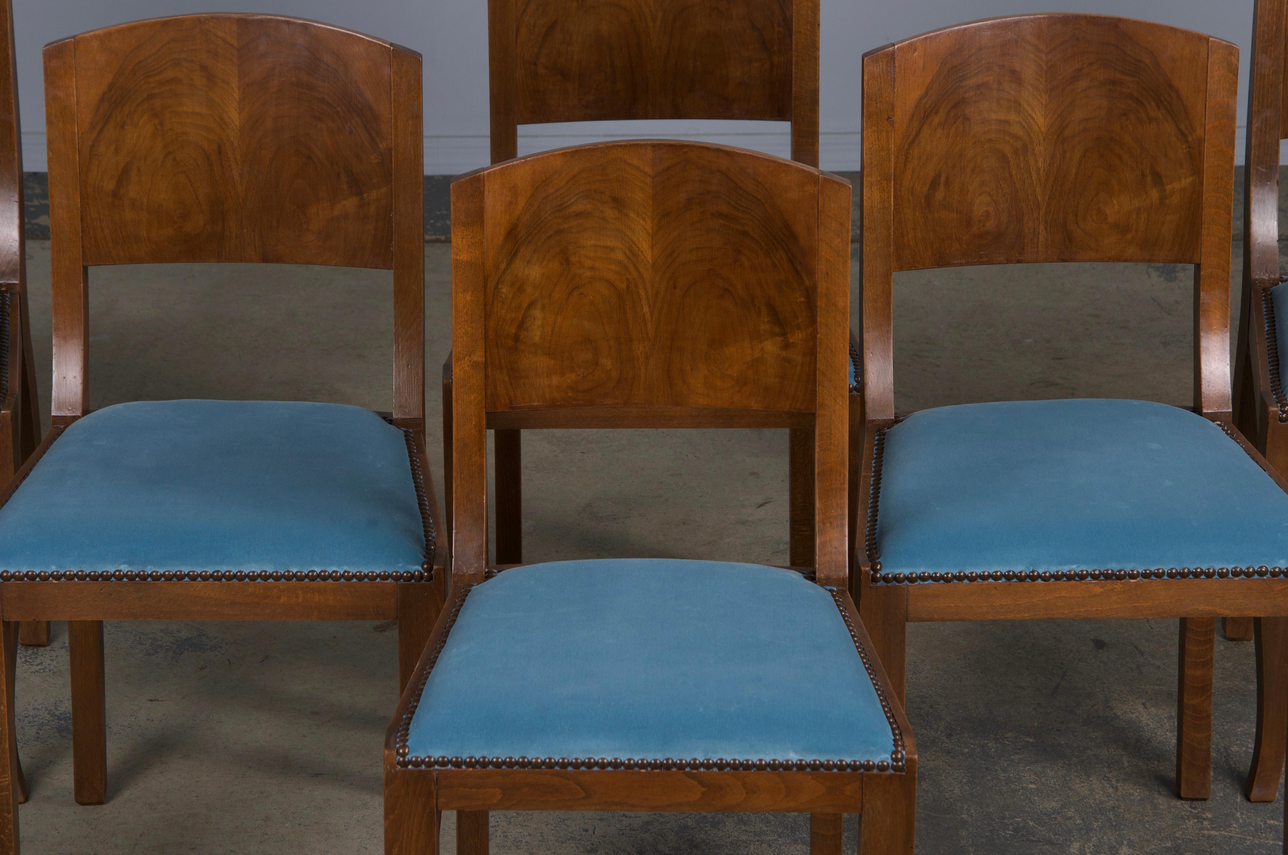 An elegant set of six 1950s French Art Deco dining chairs, thoughtfully sourced from Provence, France. Expertly hand-crafted from solid maple wood, these chairs feature a petite profile with a graceful curved back decorated with burl walnut. The