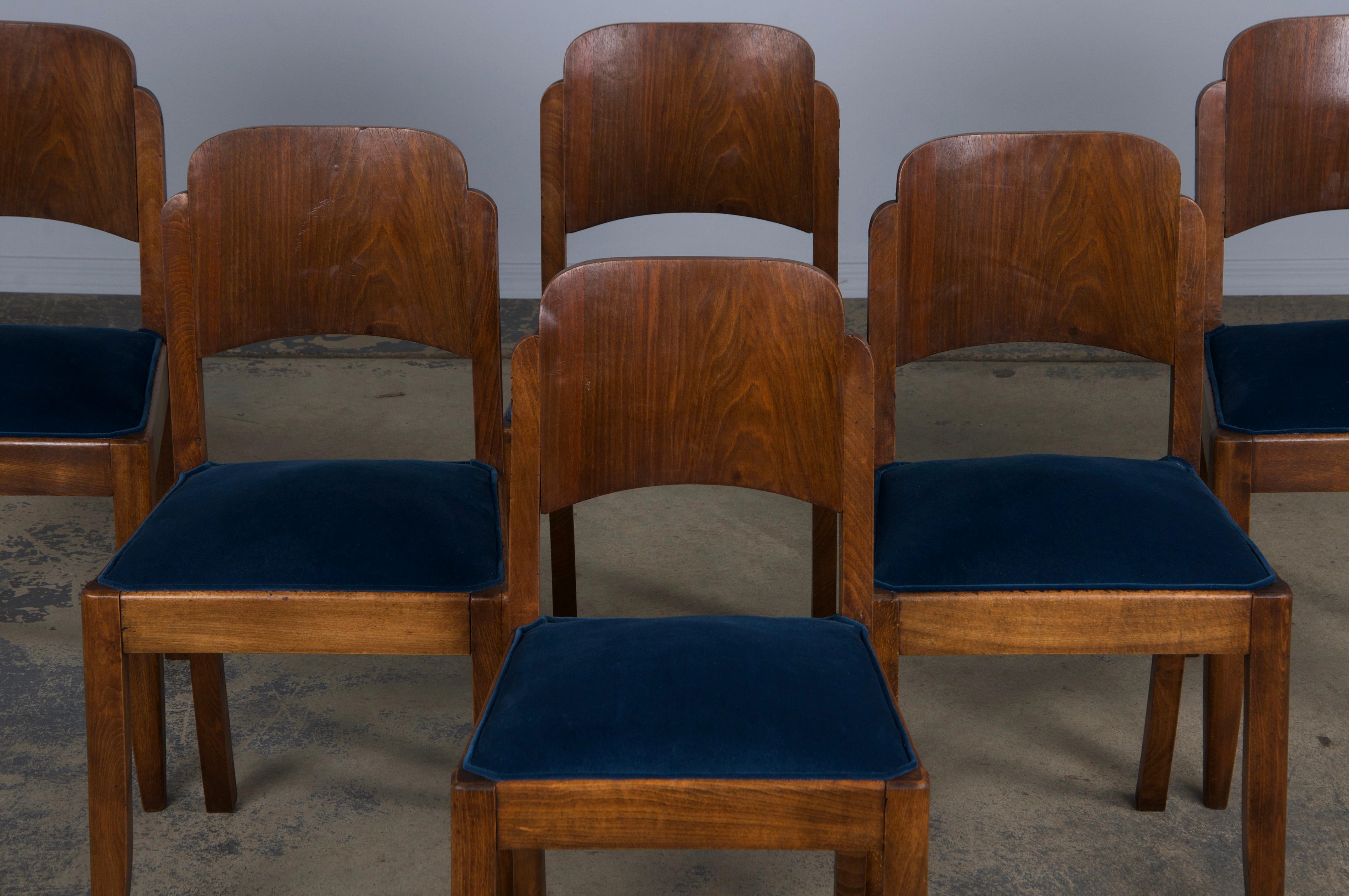 An elegant set of six 1950s French Art Deco dining chairs, thoughtfully sourced from Provence, France. Expertly hand-crafted from solid maple wood, these chairs feature a petite profile with a graceful oval back. The maple wood boasts a naturally