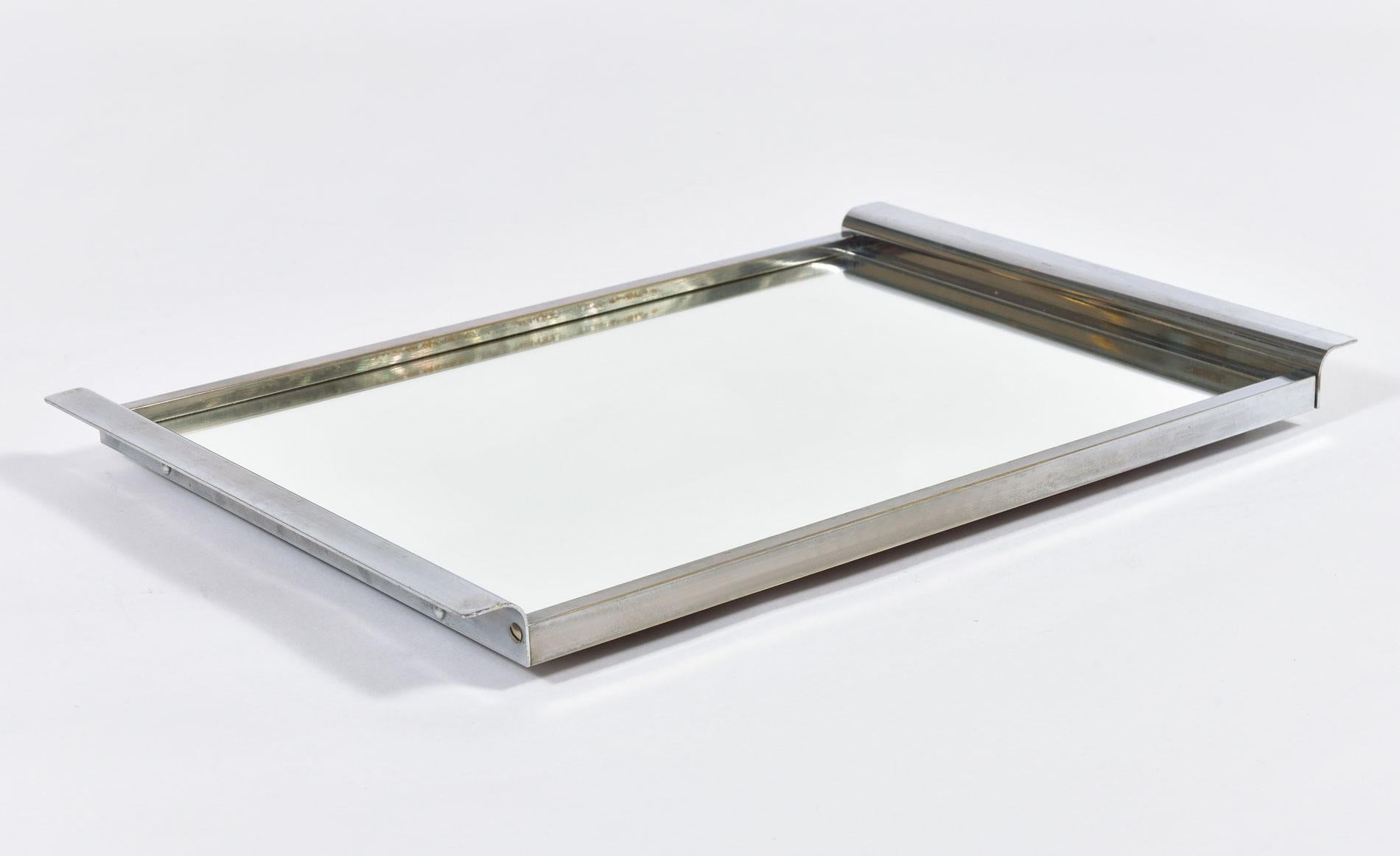 Sleek mirrored tray in an Art Deco style. Curved chrome handles compliment simple chrome frame and mirrored top. Perfect for serving drinks or for displaying bathroom or dressing-table items.