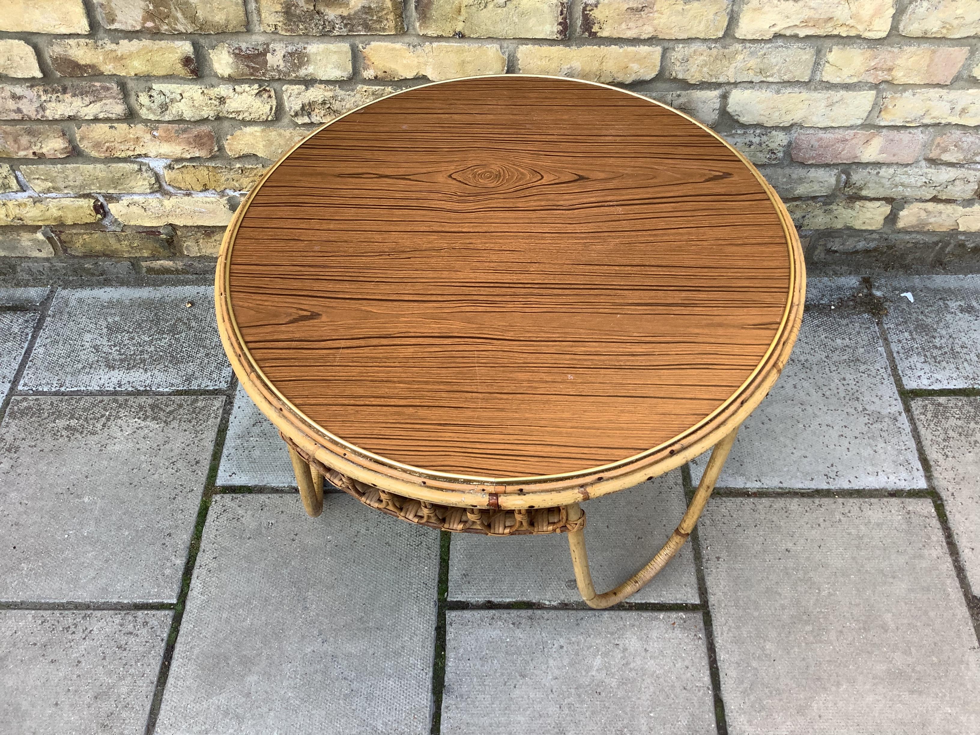 Round coffee table in bamboo with curved legs and a wooden top brass boarder
1950’s French.