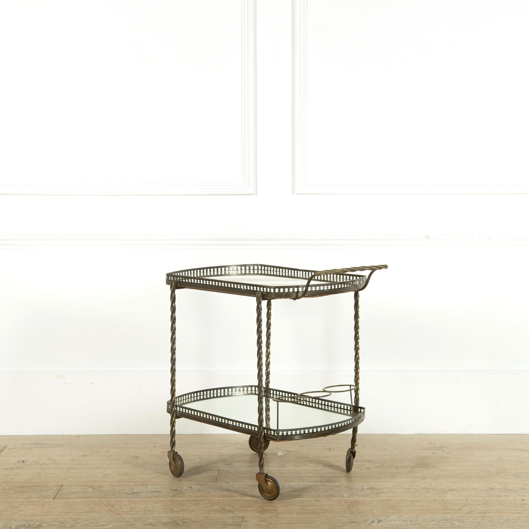 A French brass cocktail trolley with pierced gallery retaining the original perfect mirror shelves and brass bottle holders, circa 1950.