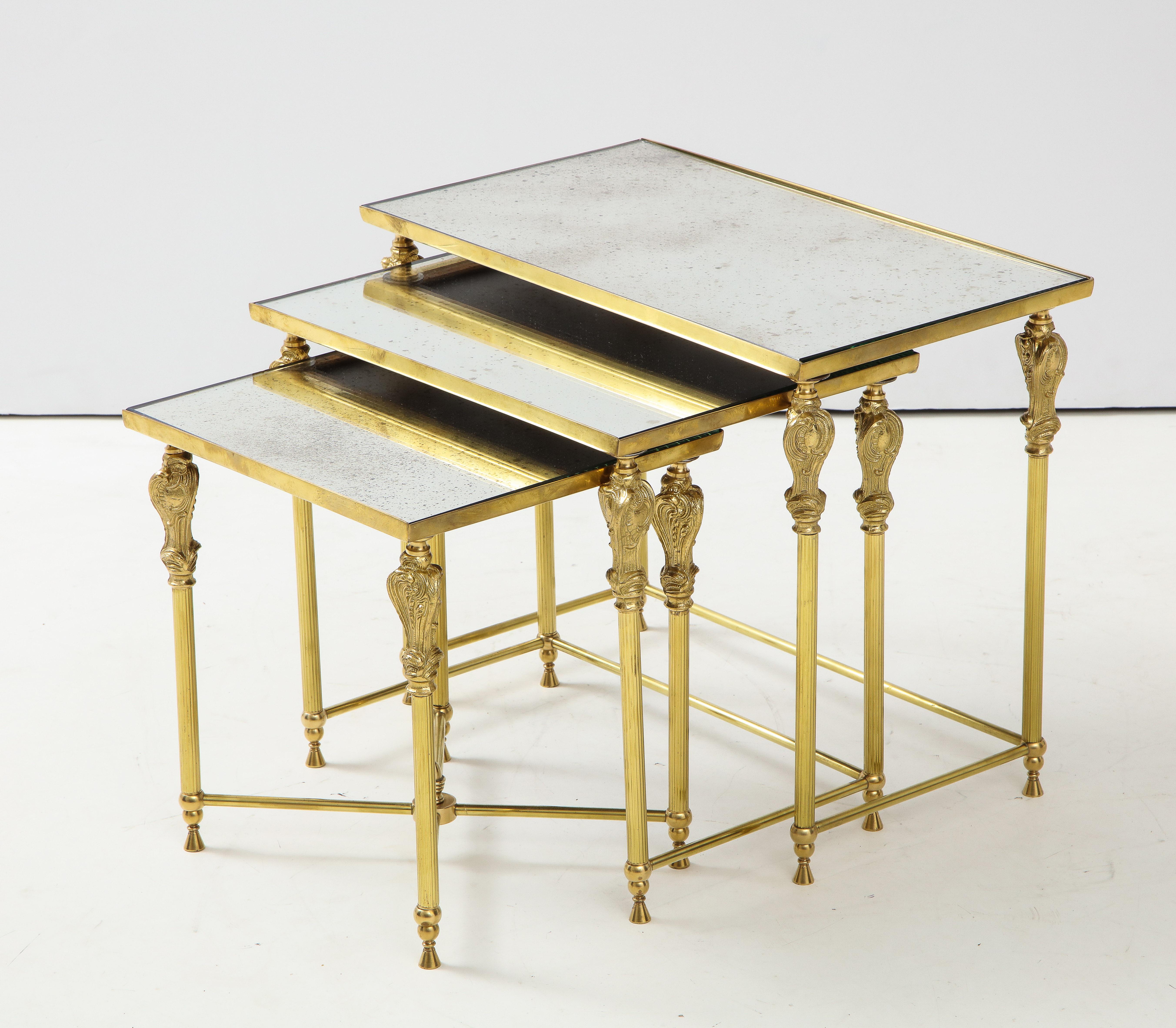 Stunning set of 1950s French bronze and brass nesting tables with glass inserts. 

Measures: Medium table width 18”, depth 12”, height 15.75
Small table width 18 depth 12”, height 14.50”.