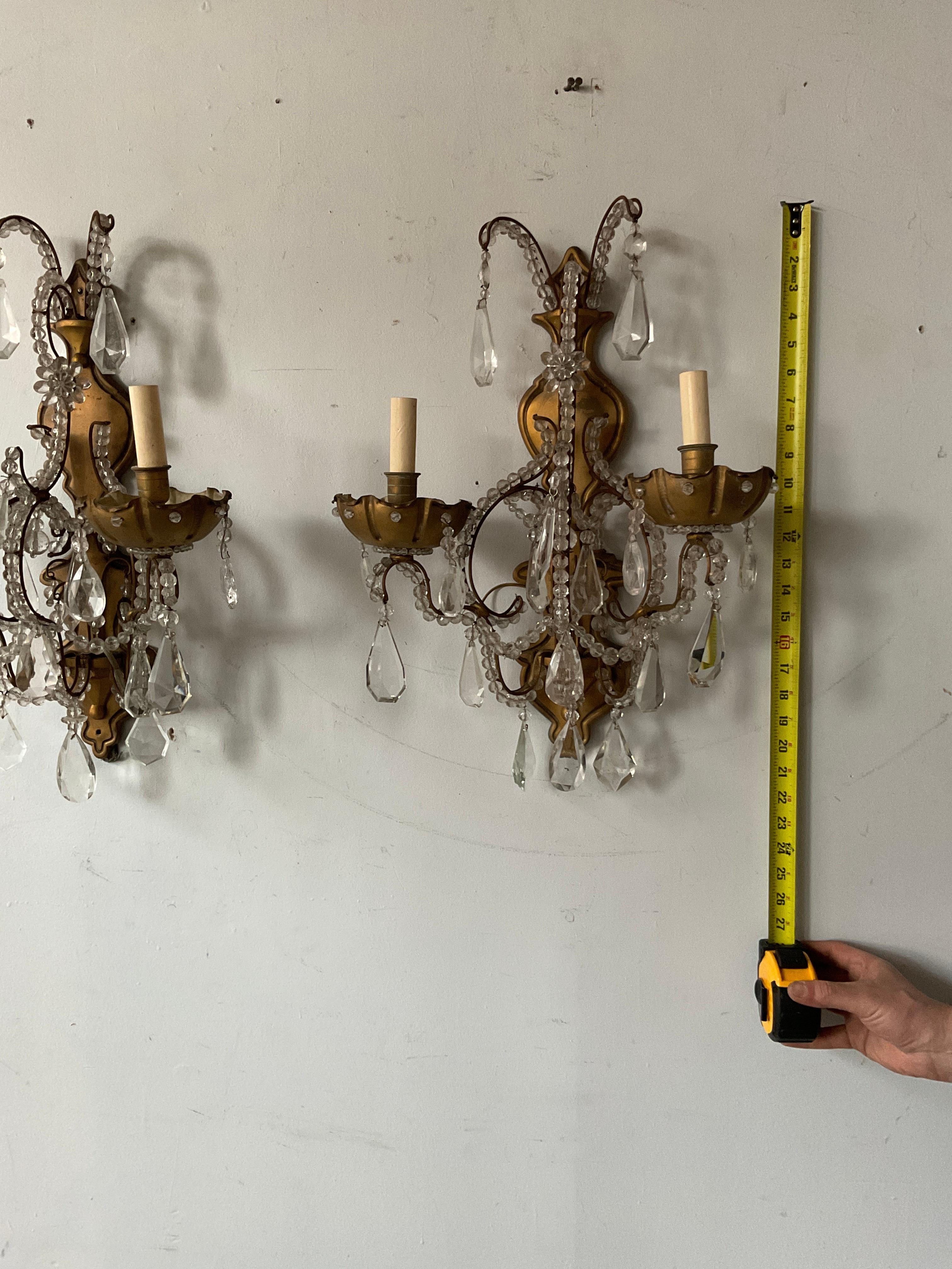 A pair of 1950s French bronze and crystal sconces.