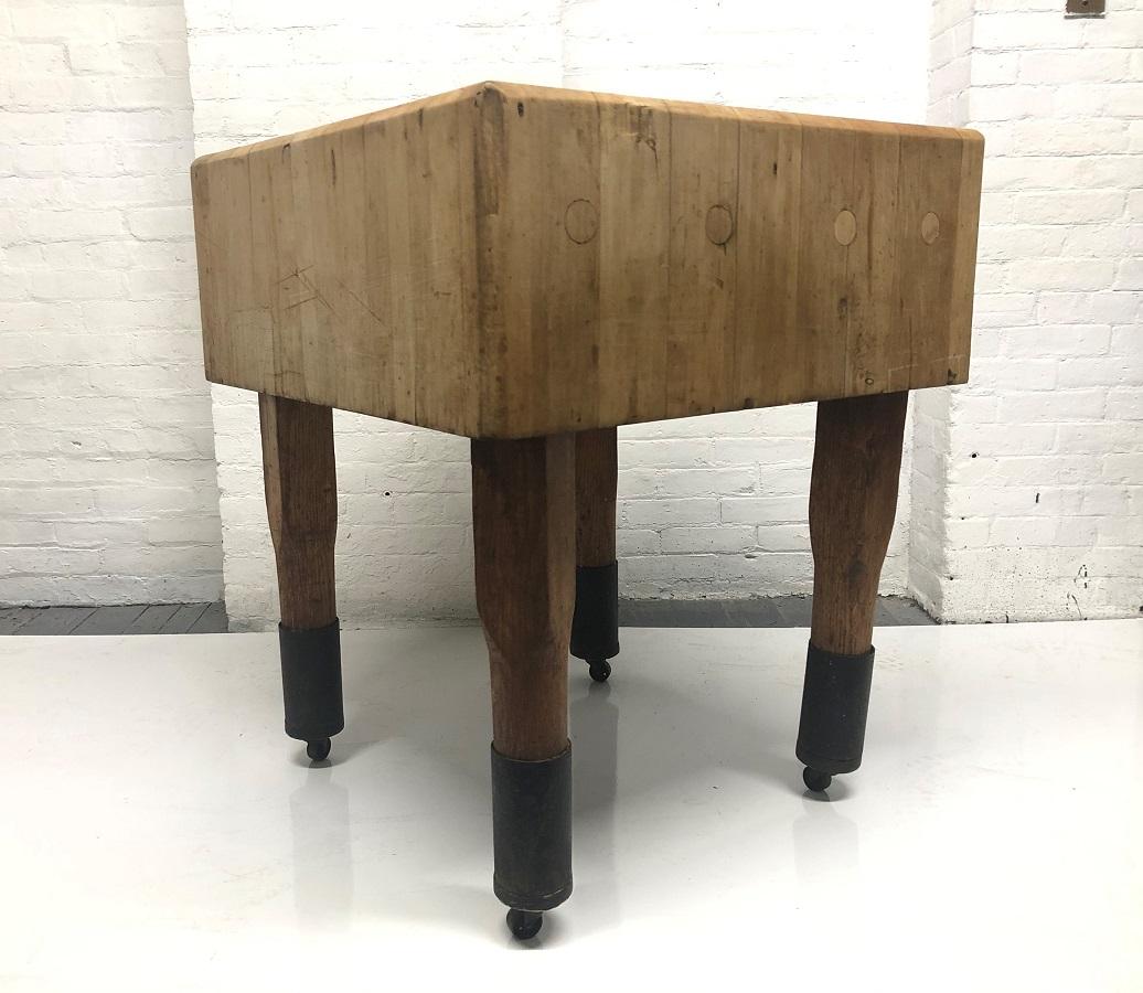 1950s French butcher block table. The butcher block is in vintage condition having original casters and is solid wood. There is metal surrounding all legs toward the bottom.
  
