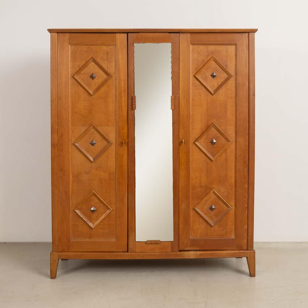 Incredible carved wood cabinet from France, 1950s. Beautiful carved wood detail on two front doors and one interior shelf. Scalloped mirror on center panel. Original brass hardware with key to lock each side. Cabinet rests on four carved wood feet.