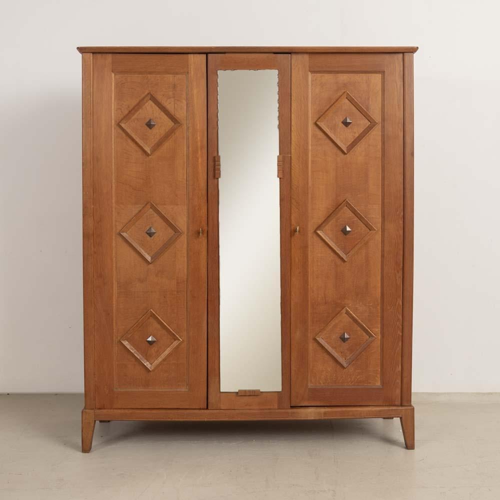Incredible carved wood cabinet from France, 1950s. Beautiful carved wood detail on two front doors and one interior shelf. Scalloped mirror on center panel. Original brass hardware with key to lock each side. Cabinet rests on four carved wood feet.