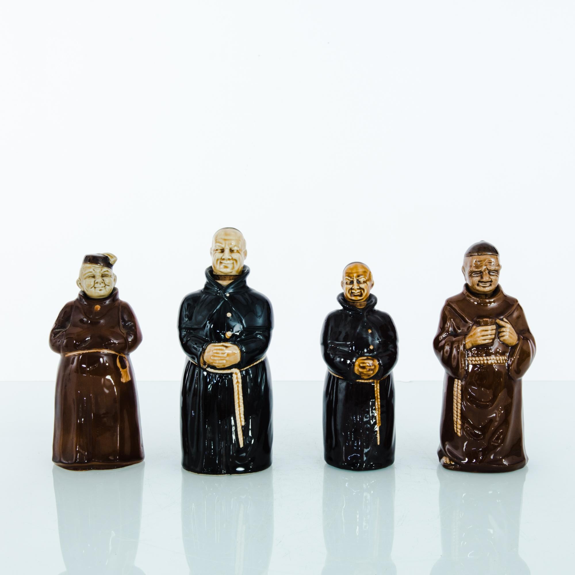 An set of French ceramic bottles, made between 1950 and 1970, in the shape of dark robed friars. Glazed in vivid colors, each bottle has a unique personality. Originally intended to store liquors, these spirited caricatures make an appealing vintage