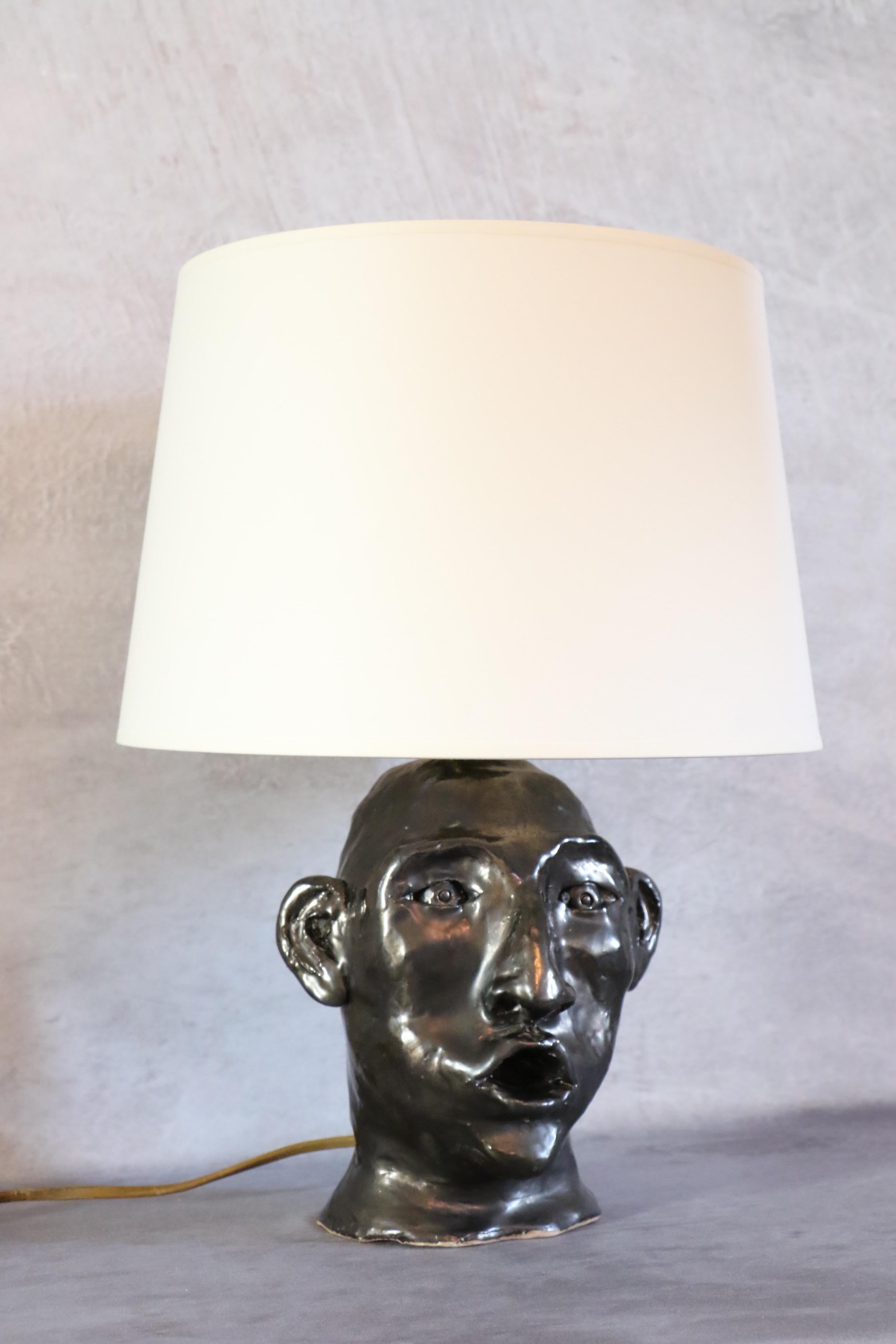 1950s French ceramic lamp with face decoration in the style of Georges Jouve

A stoneware lamp, its lustrous black enamel recalls the work of Georges Jouve or the Cloutier brothers.  
From the 1950s - 60s, the lamp is signed. A magnificent piece. A
