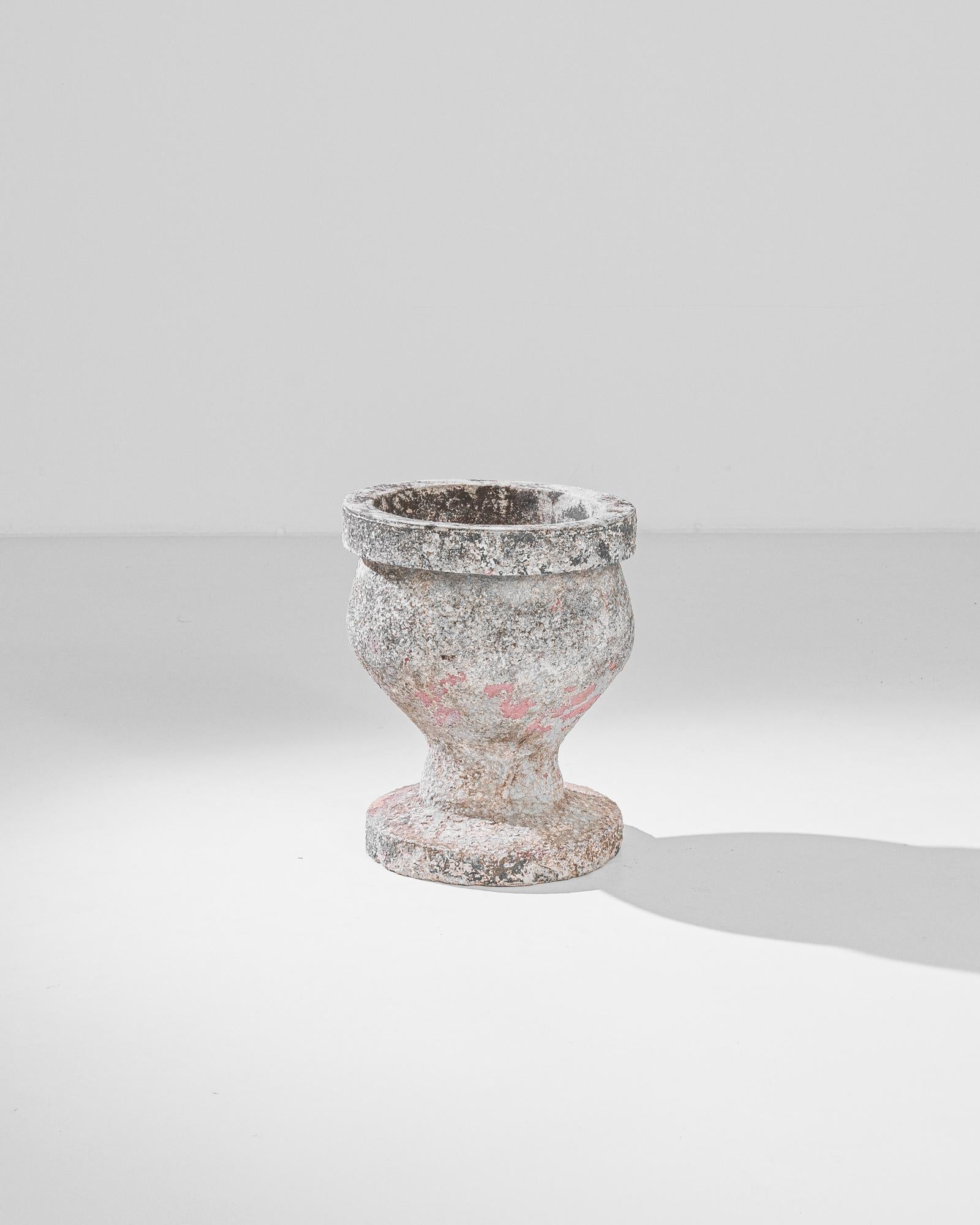 This chalice-shaped concrete planter was made in France, circa 1950. The rich texture of the distinctive patina offers a gradient from a silver grey to a pale cherry red. Its concave body firmly standing on a circular foot imparts stability and a