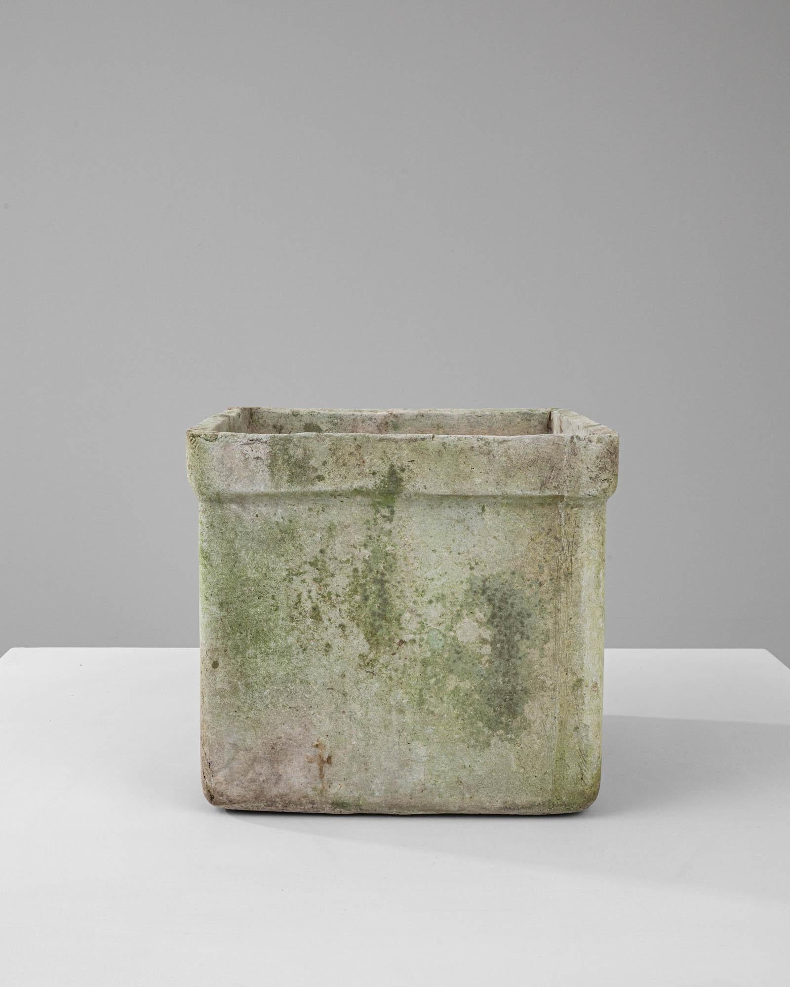 This 1950s French concrete planter embodies the strength and simplicity of post-war design. With its square form and sturdy edges, it brings a sense of solidity and permanence to any garden or outdoor area. The surface is seasoned with moss and