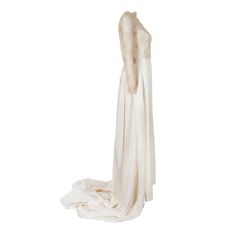 This is an extremely beautiful French couture 1950s cream lace and silk bridal gown. It is in absolutely superb vintage condition with a long train. The dress reminds us of Grace Kelly's wedding dress and will almost certainly be from the same