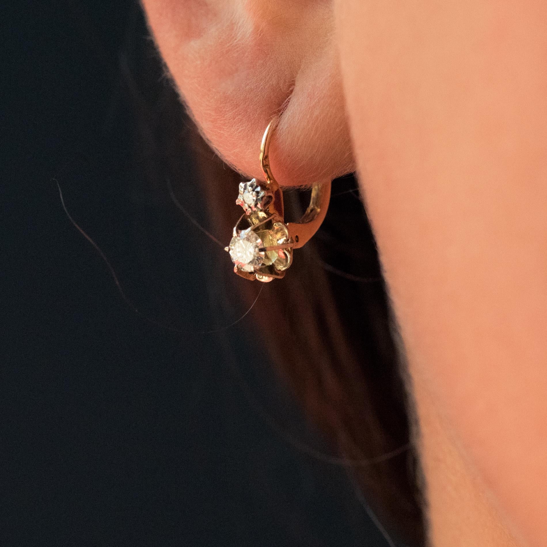 For pierced ears.
Earrings in 18 karat yellow gold, eagle's head hallmark.
A great classic in antique jewelry, each lever- back earring is set with a star studded with a diamond which surmounts another set with claws holding a modern brilliant-cut