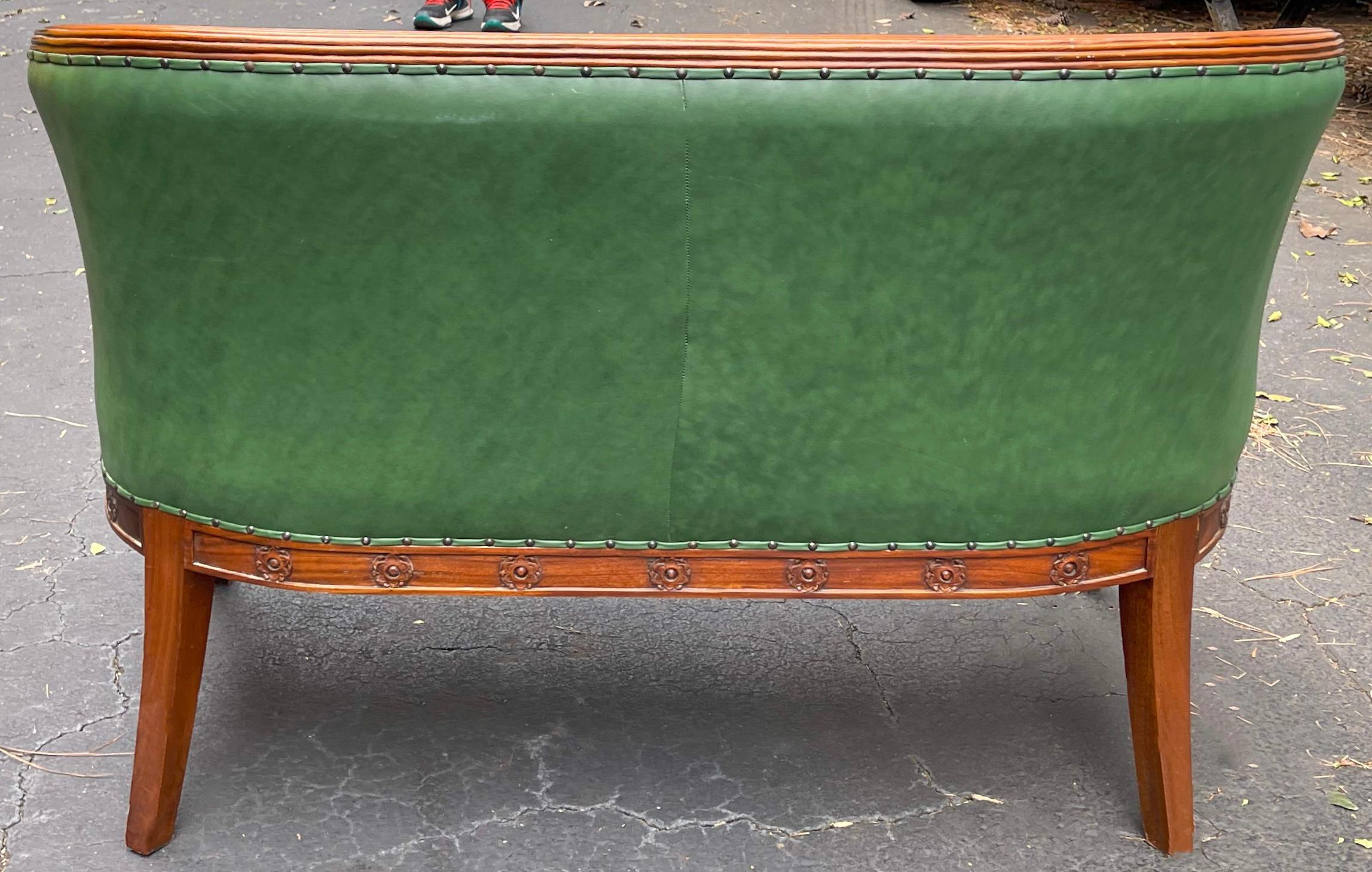 This is a handsome piece! It is a 1950s carved mahogany Empire style settee in green leather. It is unmarked. Note the carved swan arms! I have the chairs too. 

My shipping is for the Continental US only.