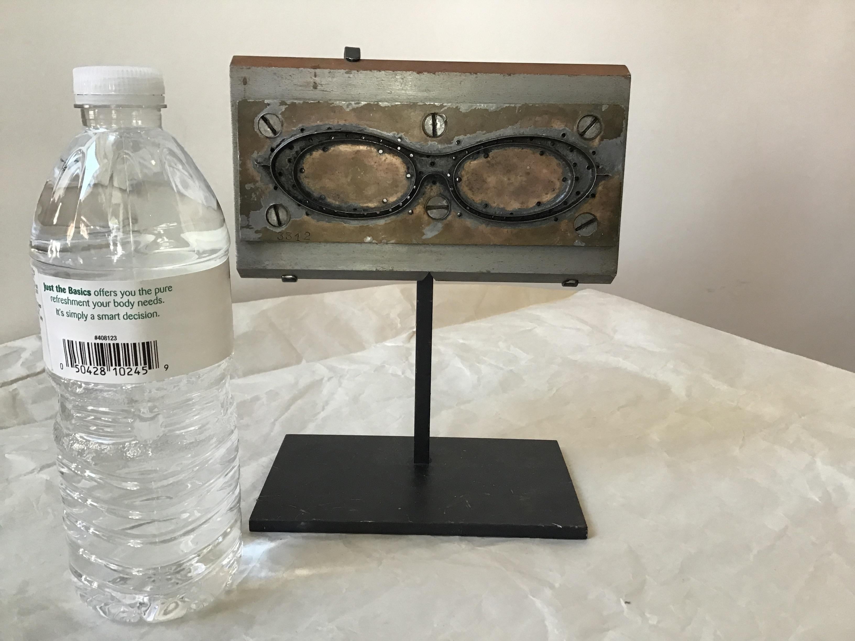 Actual 1950s French steel mold to make eyeglasses. The mold is heavy. On a custom iron base. From a Southampton, NY estate.