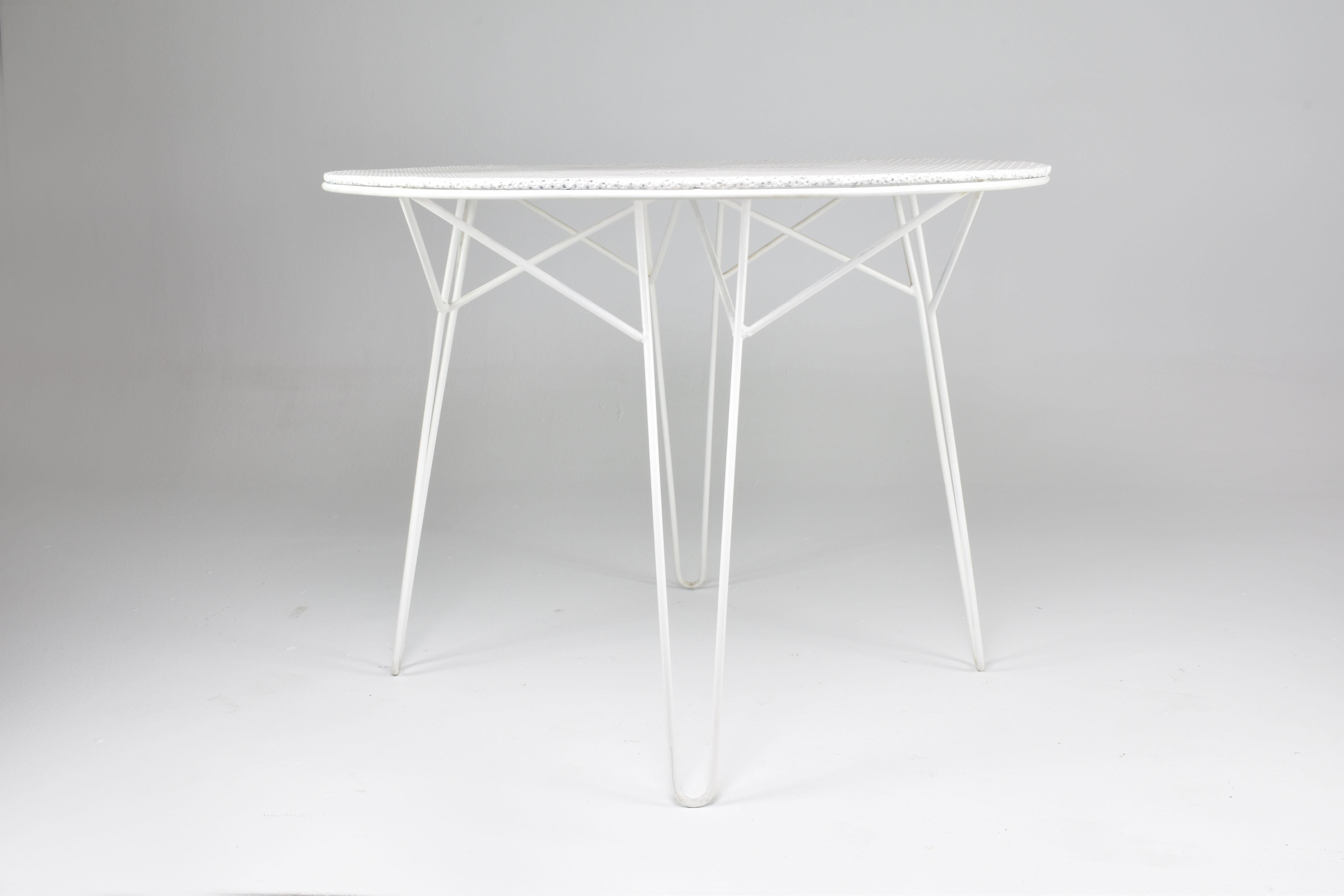 A stunning circular garden table attributed to the iconic French mid-century designer Mathieu. This collectible piece is made of his signature perforated sheet and white tubular lacquered steel.
France. Circa 1950's. 
A similar circular table is