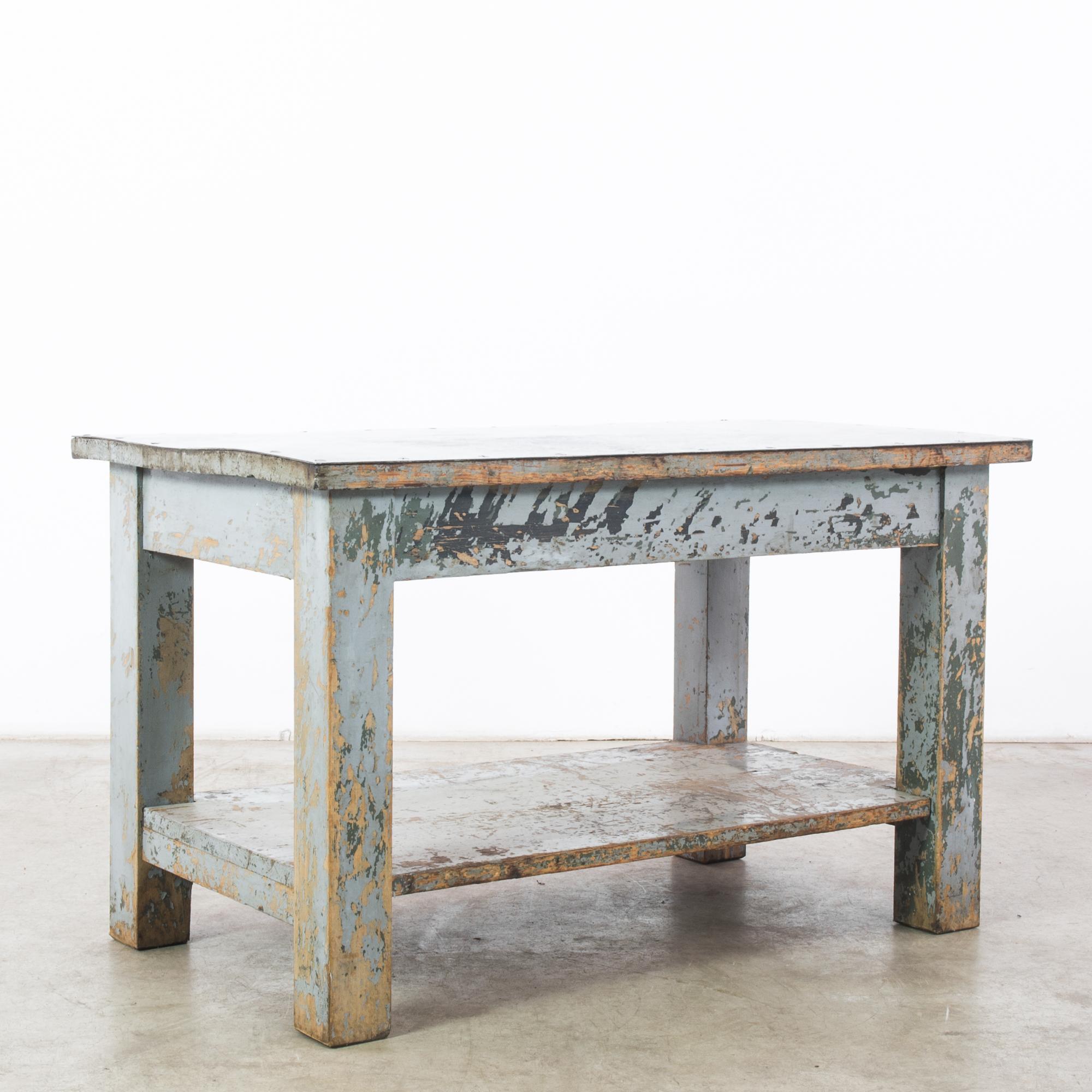 An industrial wooden side table from 1950s France with a unique patina. The simple, solid shape is enlivened by the interplay of colors: forget-me-not blue, sea green, black and natural wood. The surface of the table is capped with a sheet of metal,