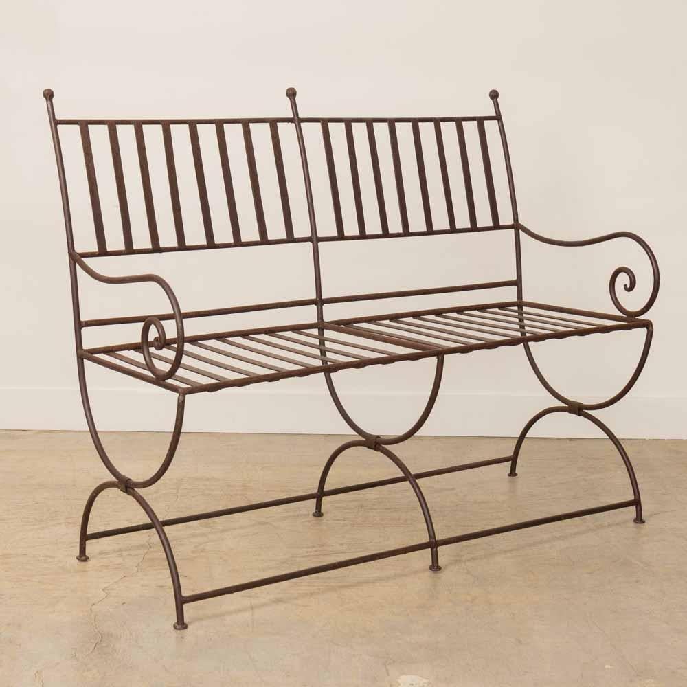 Joli banc d'extérieur en fer provenant de France. Magnifique design en fer à volutes sur les accoudoirs, avec dossier et assise en fer arrondi. La banquette repose sur un piétement curule à 6 branches. Forme étonnante et unique, parfaite pour une