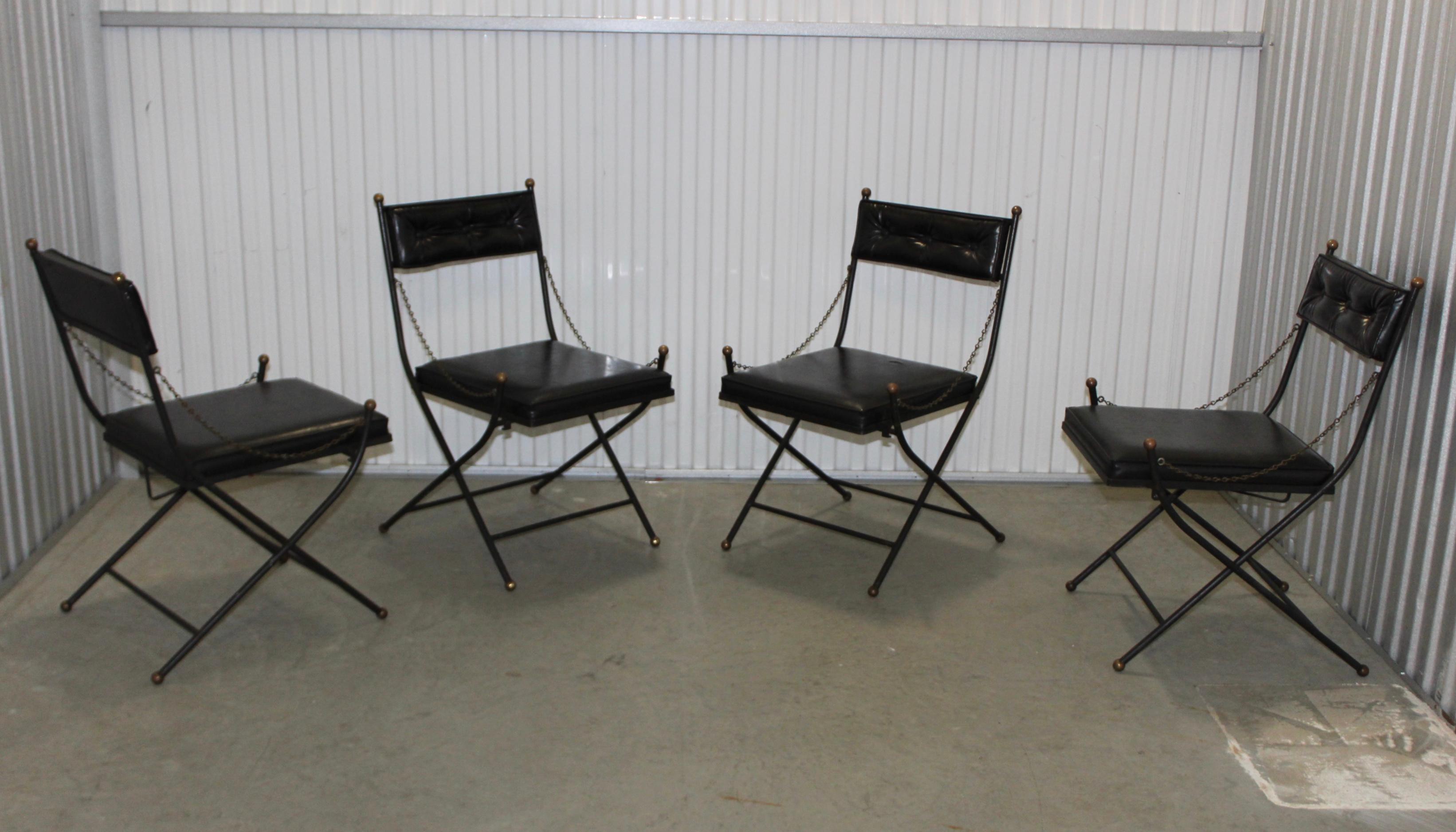 Stunning set of four 1950s solid iron folding chairs with brass detail in the style of Maison Jansen.