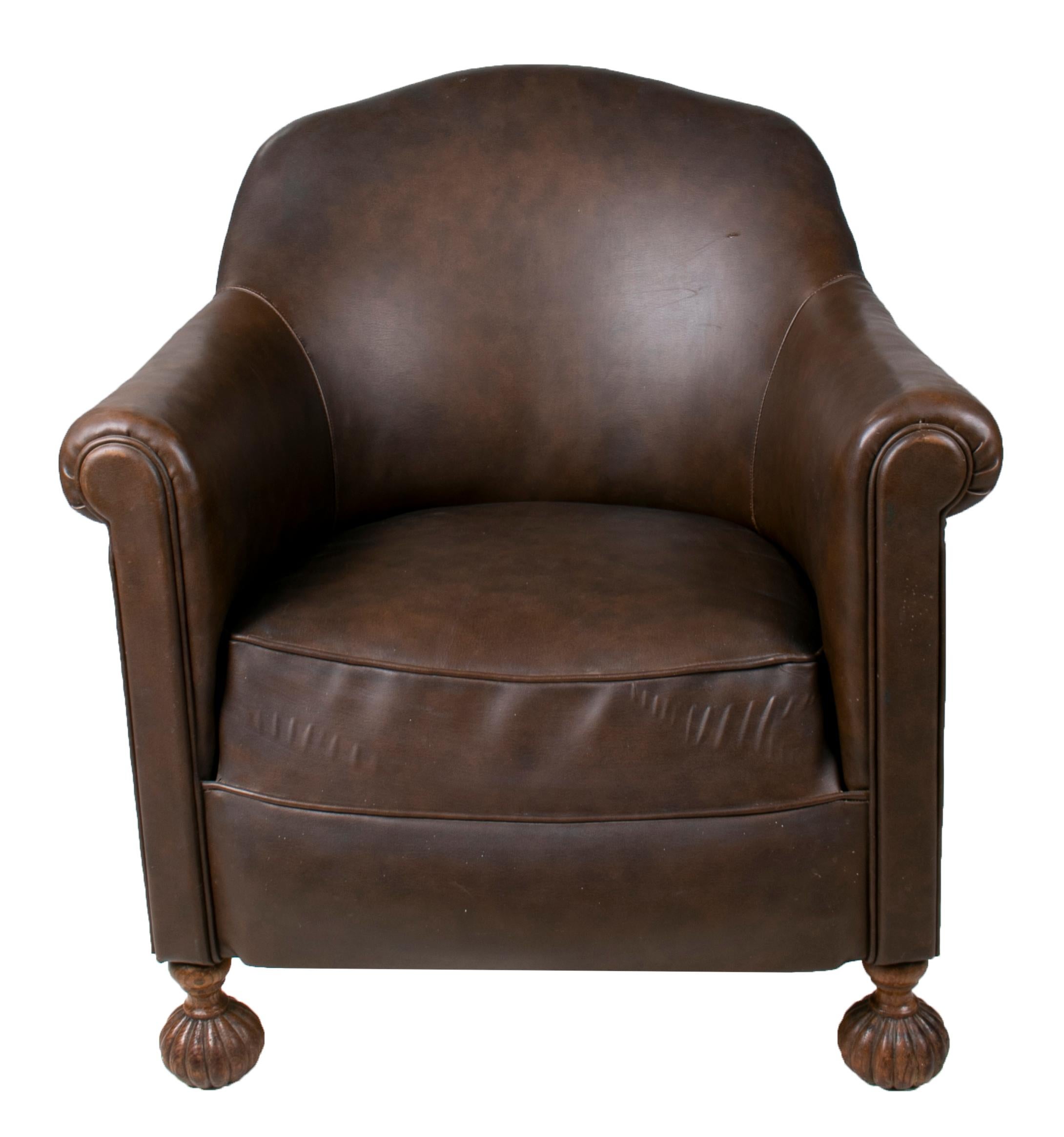 1950s French leather imitation armchair with ornate carved wooden rounded feet and arm rest. 

  