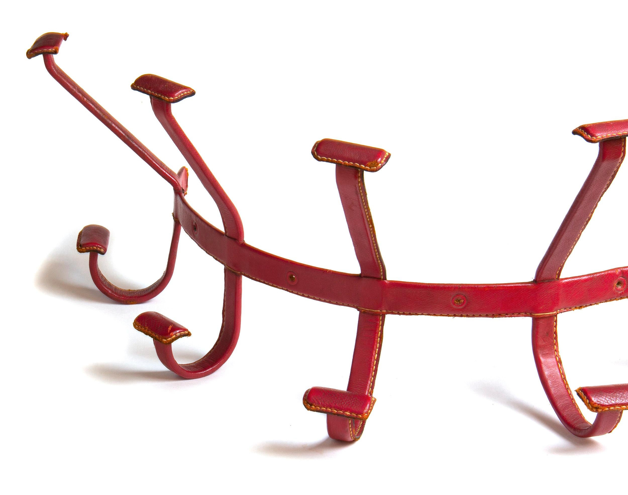 A red leather coat and hat rack with hooks, rounded for mounting on pillars or columns.