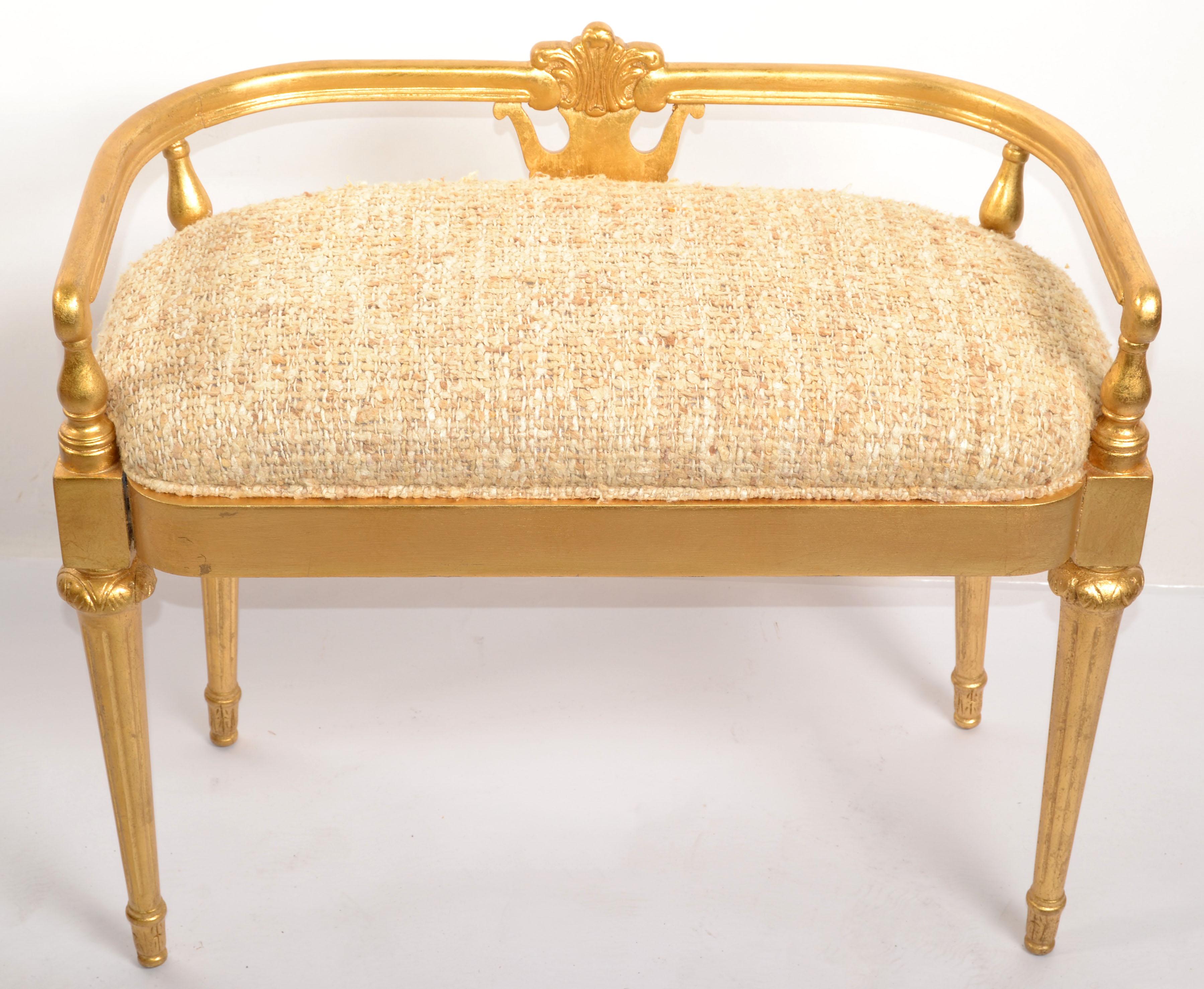 Un'elegante panca francese del XX secolo in stile Luigi XIV in legno dorato. La panca decorativa è sollevata su quattro gambe con piedi a forma di topie sotto una colonna circolare scanalata e affusolata. Sopra c'è il fregio in legno dorato con un
