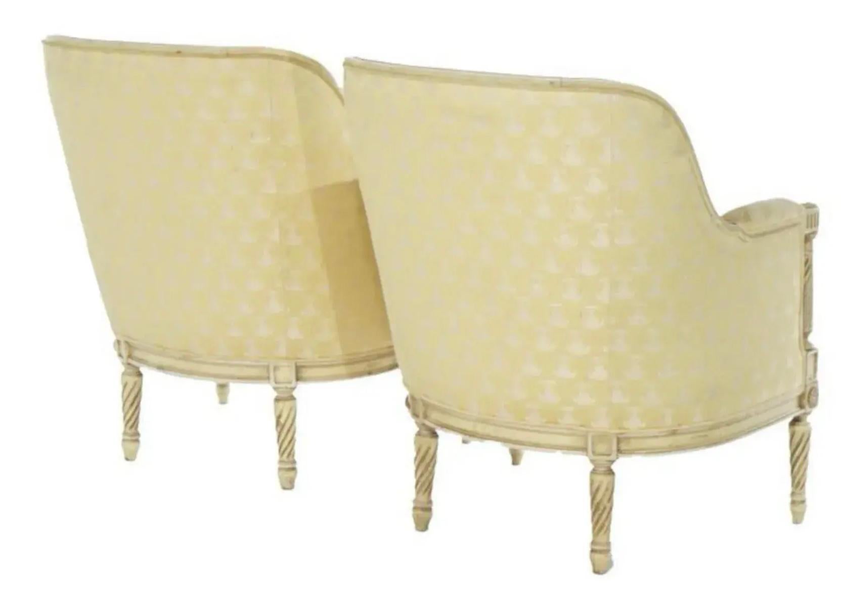 Elles sont magnifiques ! Je propose une paire de chaises bergères françaises de style Louis XVI sculptées et peintes des années 1950. Elles ont été taillées à la main par Hibreton, un fabricant de meubles très réputé. La sellerie jaune vintage est
