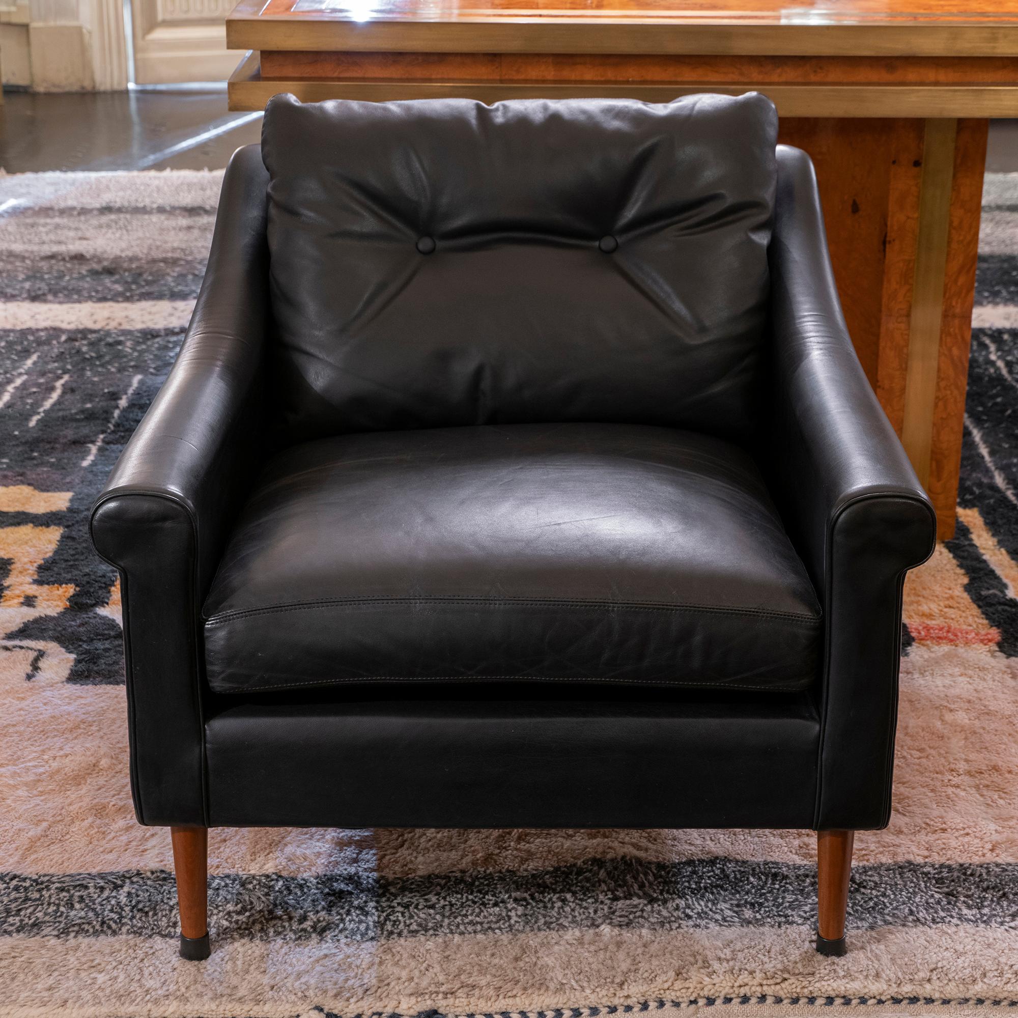 Pair of Mid-Century Modern armchairs, original black leather in perfect condition and vintage patina. Wood legs with original rubber caps, France, circa 1950s.